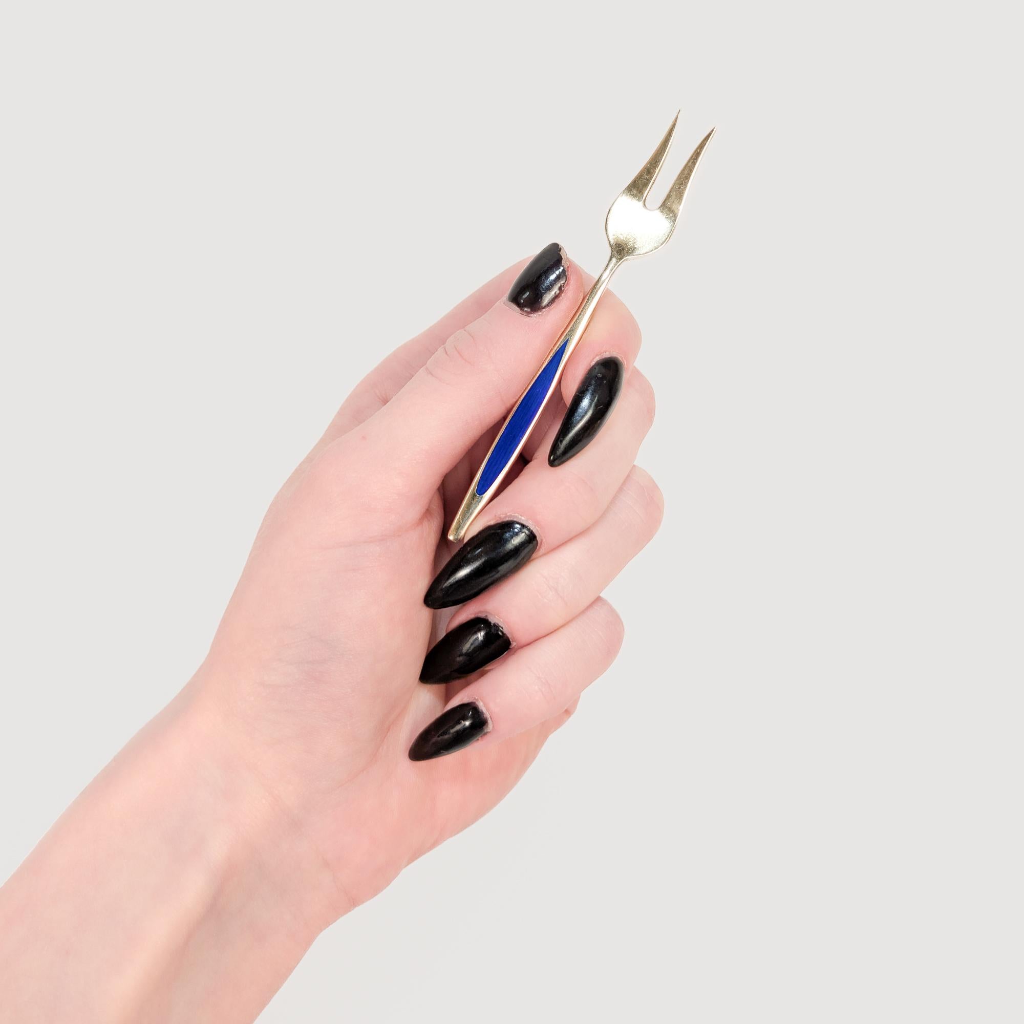 Un raffinato set di 10 forchette da cocktail moderne danesi.

Da Meka.

In argento sterling dorato.

Con decorazioni in smalto arabescato sui manici in bianco, giallo, verde e due tonalità di blu.

Marcato sul retro.

Un design Mid-Century