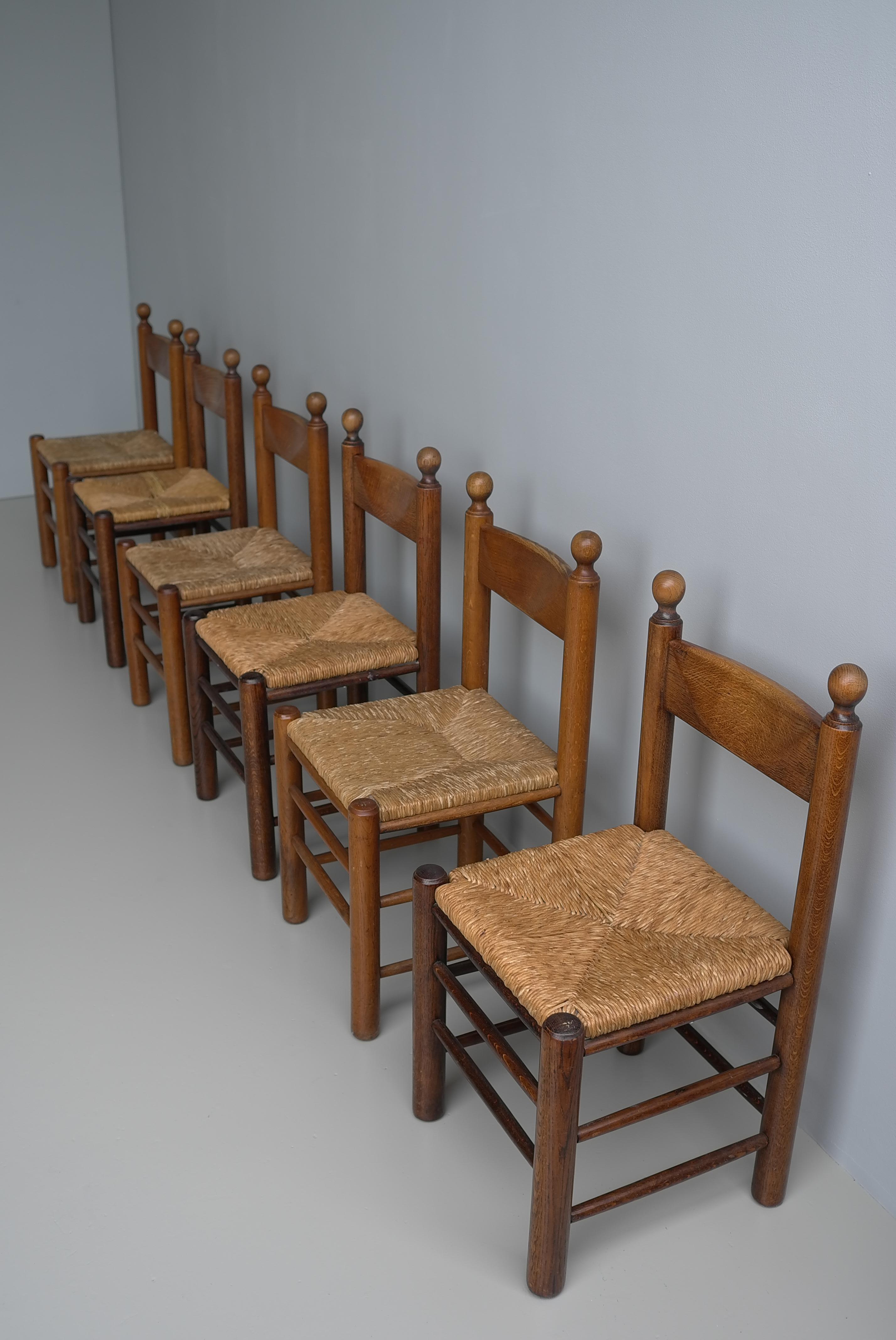 Oak and Rush Chairs in Style of Charles Dudouyt , France 1960's
Solid Oak chairs with rush seats, with lovely Patina to the wood. The listed price is per chair and we have 12 chairs in total available. 

