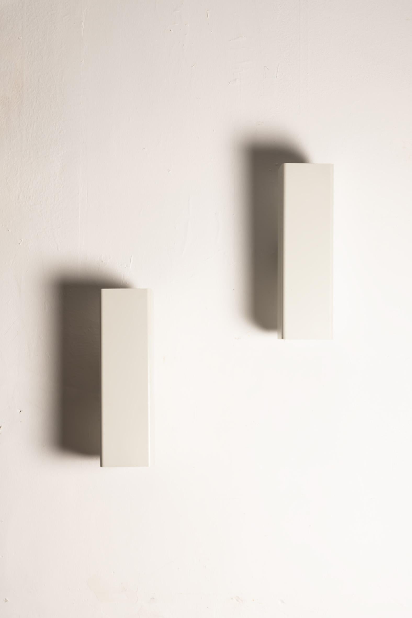 Elegante set di appliques vintage dell'era spaziale, progettate e prodotte da Erco in Germania, circa anni Settanta.
Raffinato esempio di illuminazione architettonica europea del periodo, ogni applique presenta un corpo cilindrico minimale in