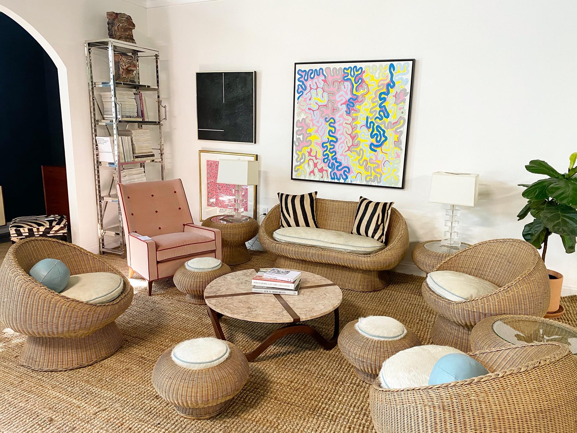 In the style of Eero Aarnio.

The romance of rattan! Homey, versatile, and always stylish. This set is comprised of a loveseat, three lounge chairs, three ottomans, and three side tables. Custom made Brazilian ivory cowhide cushions add warmth and