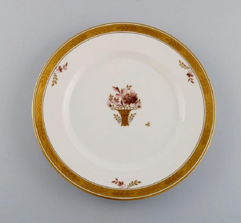 10 Royal Copenhagen Golden Basket dinner plates in hand-painted porcelain with flowers and gold decoration. 1960s. 
Model number 595/9586.
Diameter: 25 cm.
In excellent condition.
Stamped.
1st factory quality.