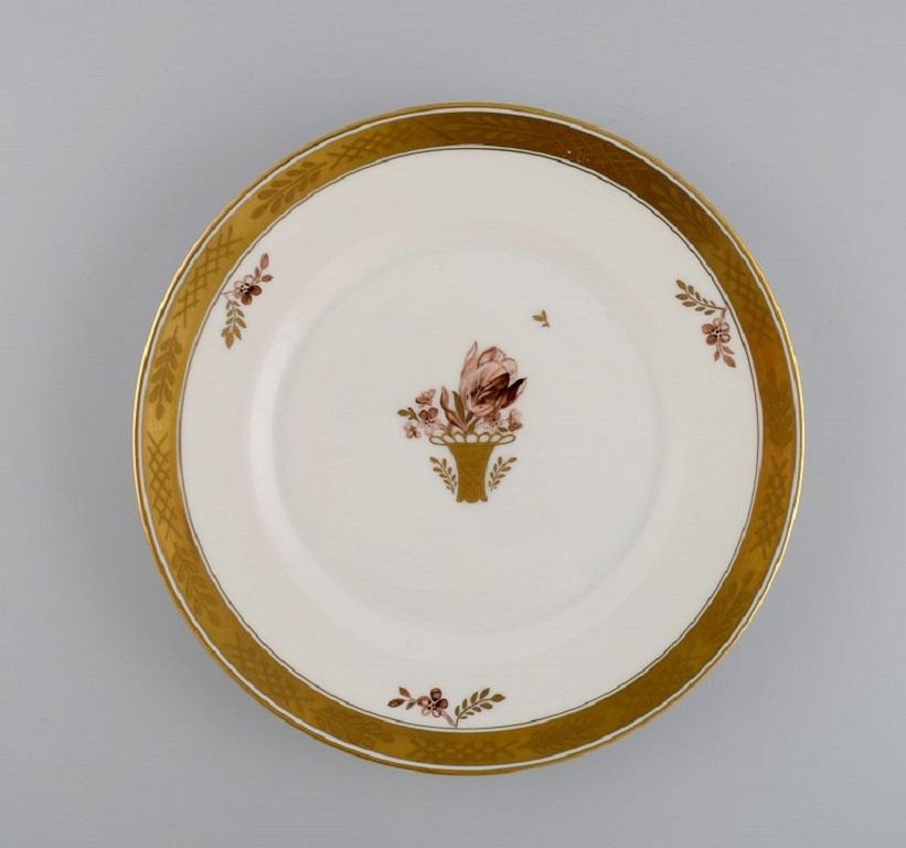 10 Royal Copenhagen Golden Basket lunch plates in hand-painted porcelain with flowers and gold decoration. 1960s. 
Model number 595/9589.
Diameter: 22 cm.
In excellent condition.
Stamped.
1st factory quality.