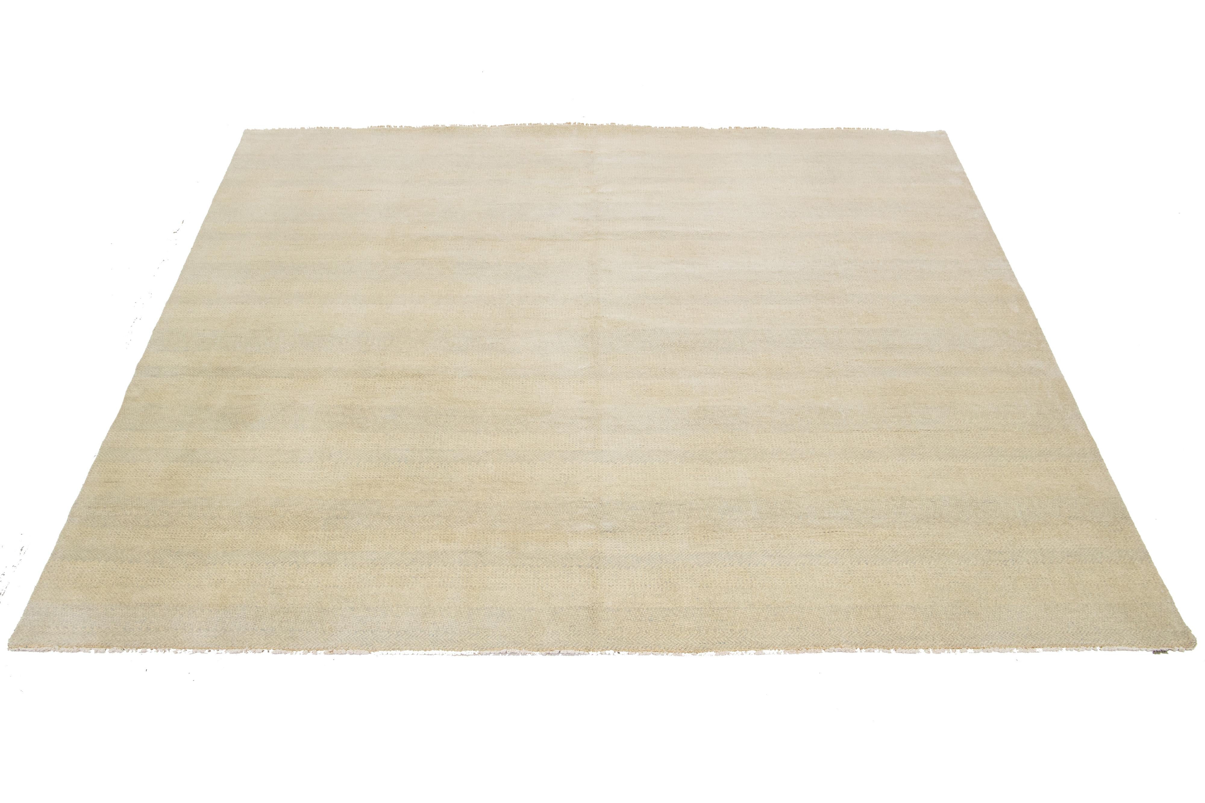 This hand-knotted Square wool rug showcases a modern design featuring a thoughtfully crafted blend of beige tones, highlighted by intricate geometric patterns that catch the eye.

This rug measures 10'1