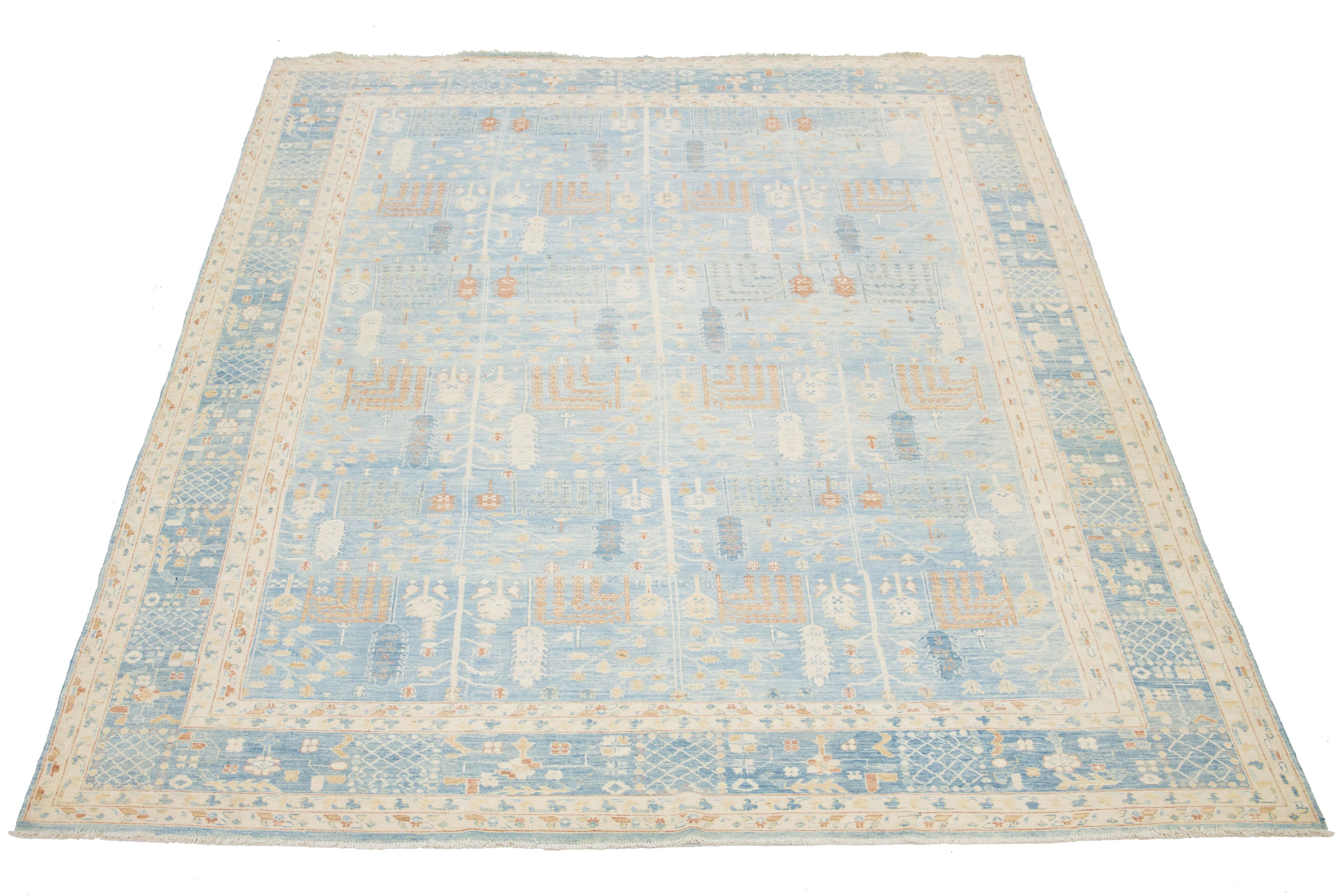 Ce superbe tapis moderne en laine Khotan nouée à la main présente un fond bleu clair serein, joliment encadré par une bordure au dessin complexe ornée d'élégants accents beiges et rouille.

Ce tapis mesure 9'10