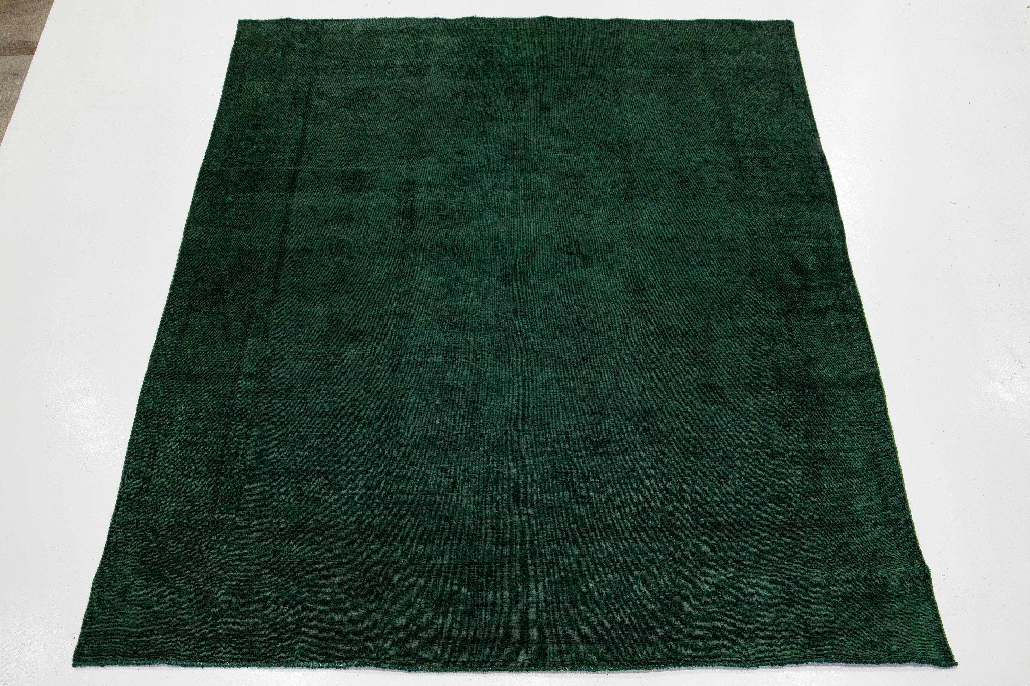 Questo squisito tappeto persiano vintage in lana annodato a mano presenta un campo verde. Presenta uno splendido disegno floreale all-over ornato da accenti neri. Il motivo a medaglione, splendidamente tinto, aggiunge un tocco di eleganza a