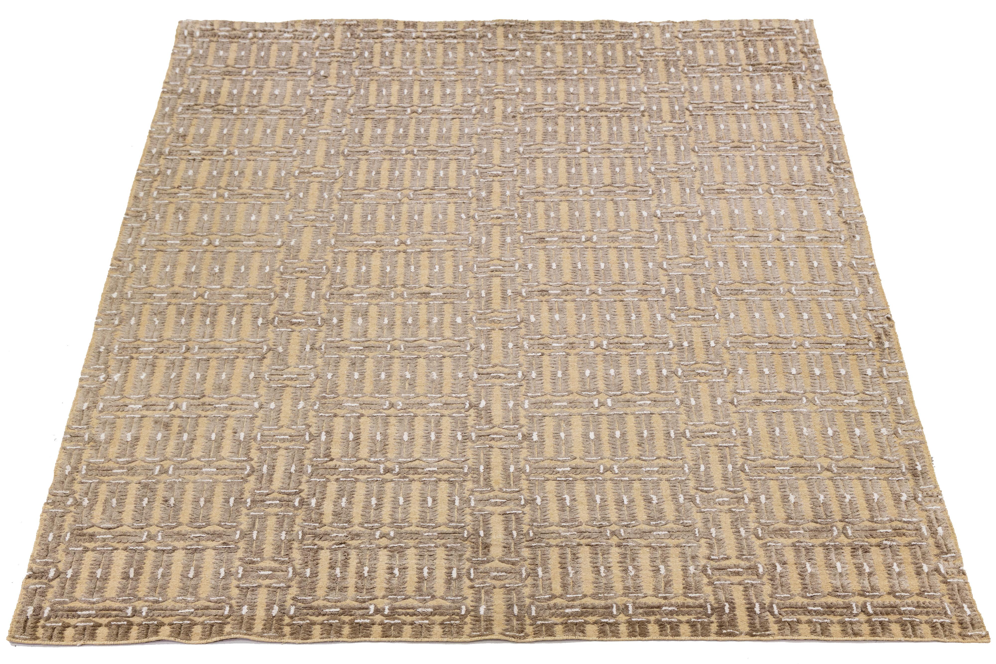 This beautiful modern Soumak hand-knotted wool rug has a tan field. It features beige accents in a gorgeous all-over geometric design.

This rug measures 9'11