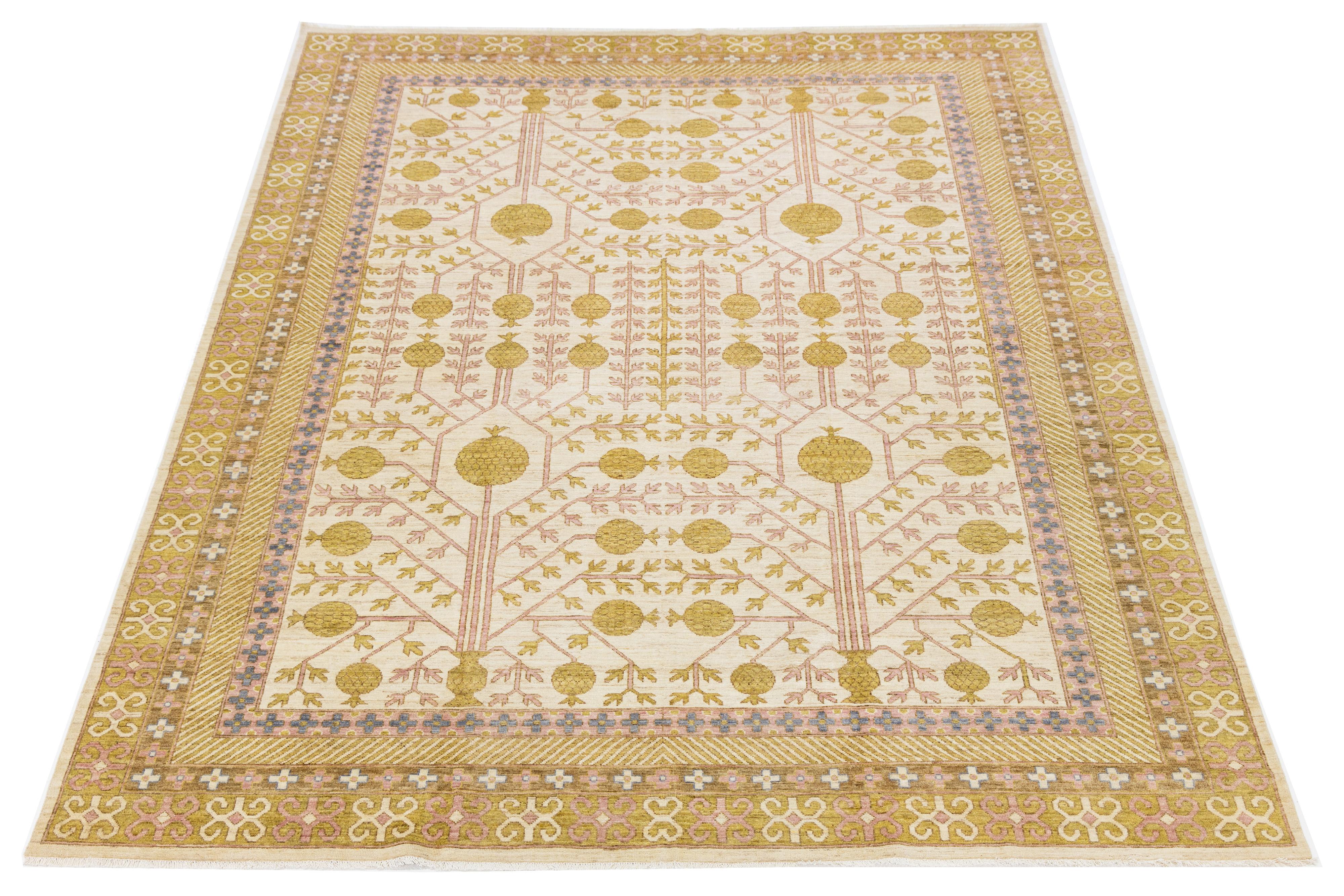 Dieser handgeknüpfte Wollteppich im Khotan-Stil zeichnet sich durch ein beigefarbenes Feld aus, das durch subtile Akzente in Gold, Rosa, Beige und Blau elegant ergänzt wird. Sein Design zeigt ein komplexes All-Over-Interlock-Muster, das