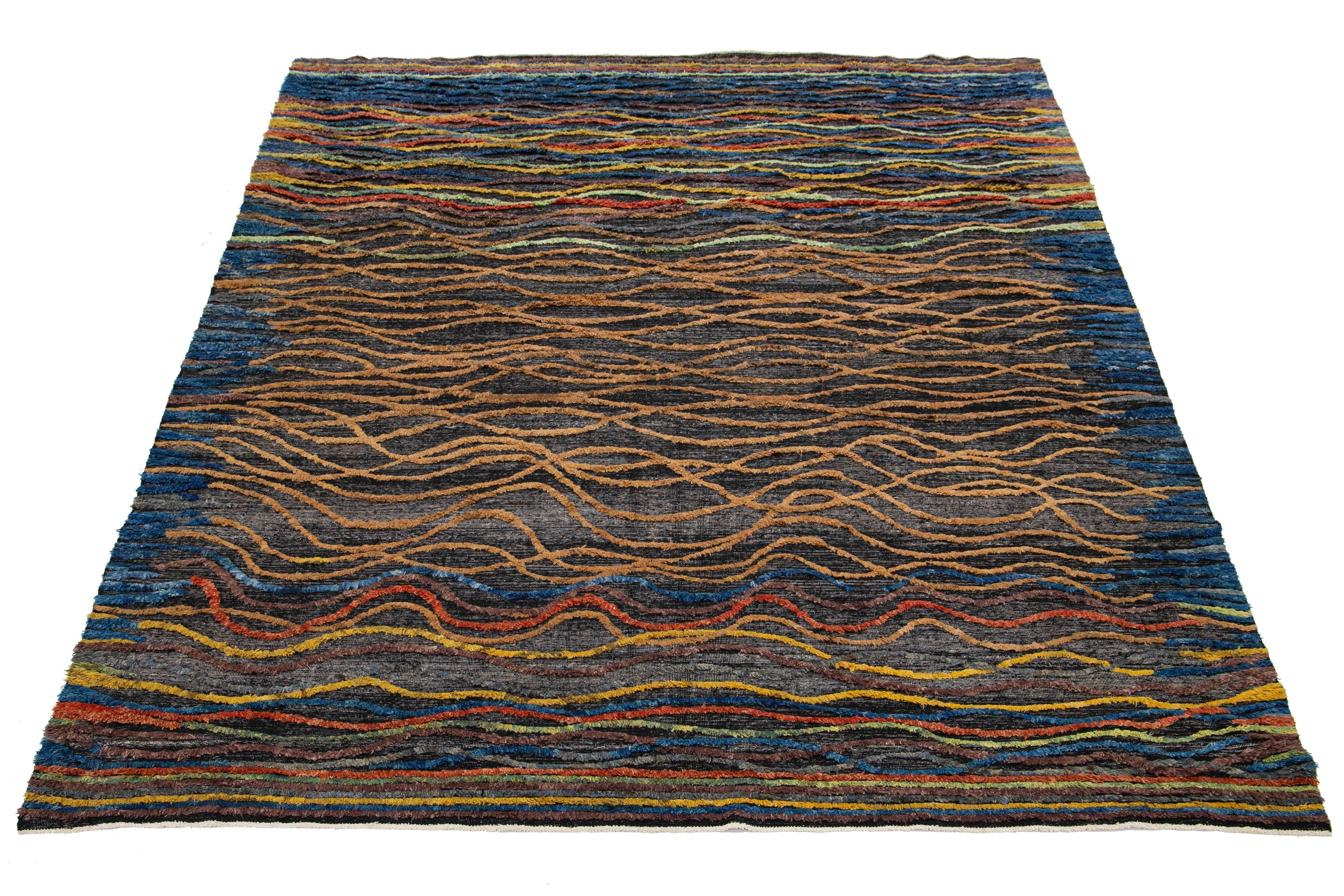 Transforma tu salón con esta moderna alfombra de lana de estilo marroquí. Hecho a mano con esmero, presenta un vibrante diseño abstracto multicolor sobre fondo gris, que combina el estilo contemporáneo con el arte tradicional marroquí. Hecho de lana