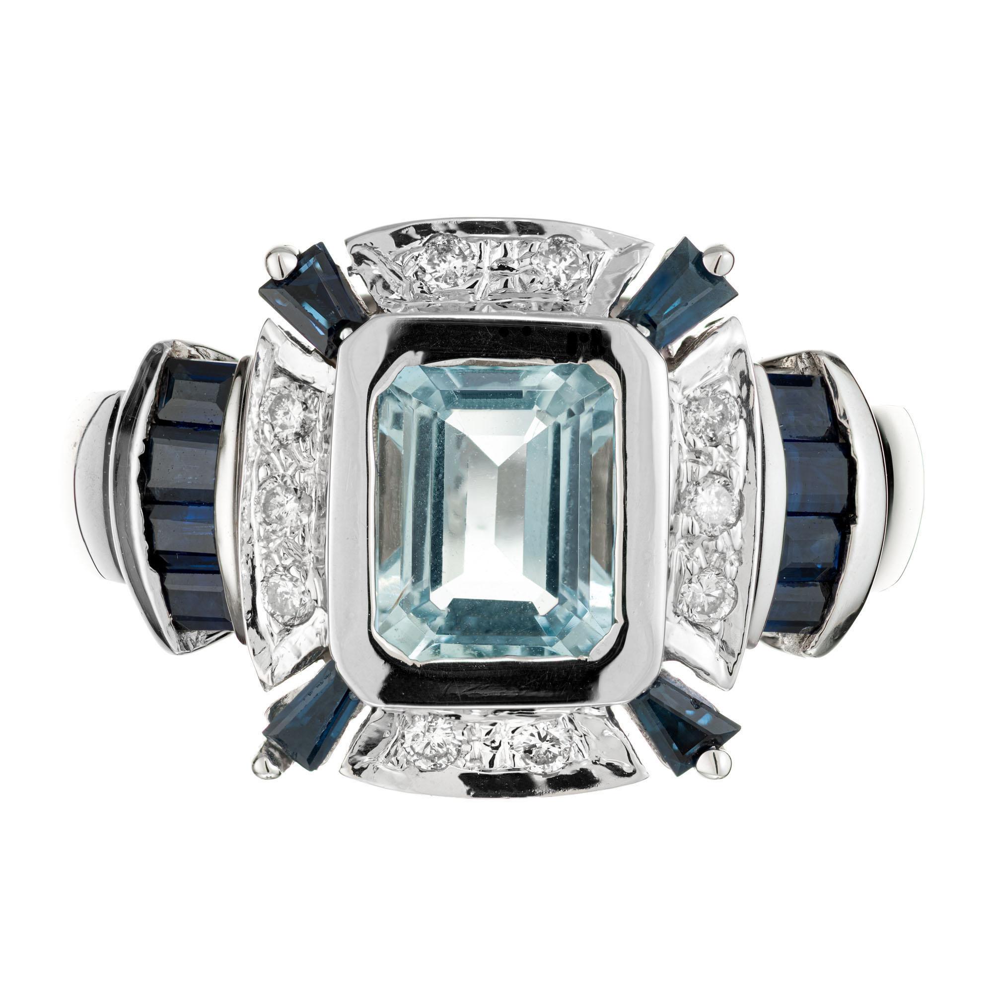 Emerald cut aqua Art Deco cocktail style ring. 1.00 Blue center Aqua with 12 baguette and 10 round diamonds.

1 rectangular blue aquamarine, VS approx. 1.00ct
12 baguette dark blue sapphires, SI approx. .44cts
10 round brilliant cut diamonds, G-H