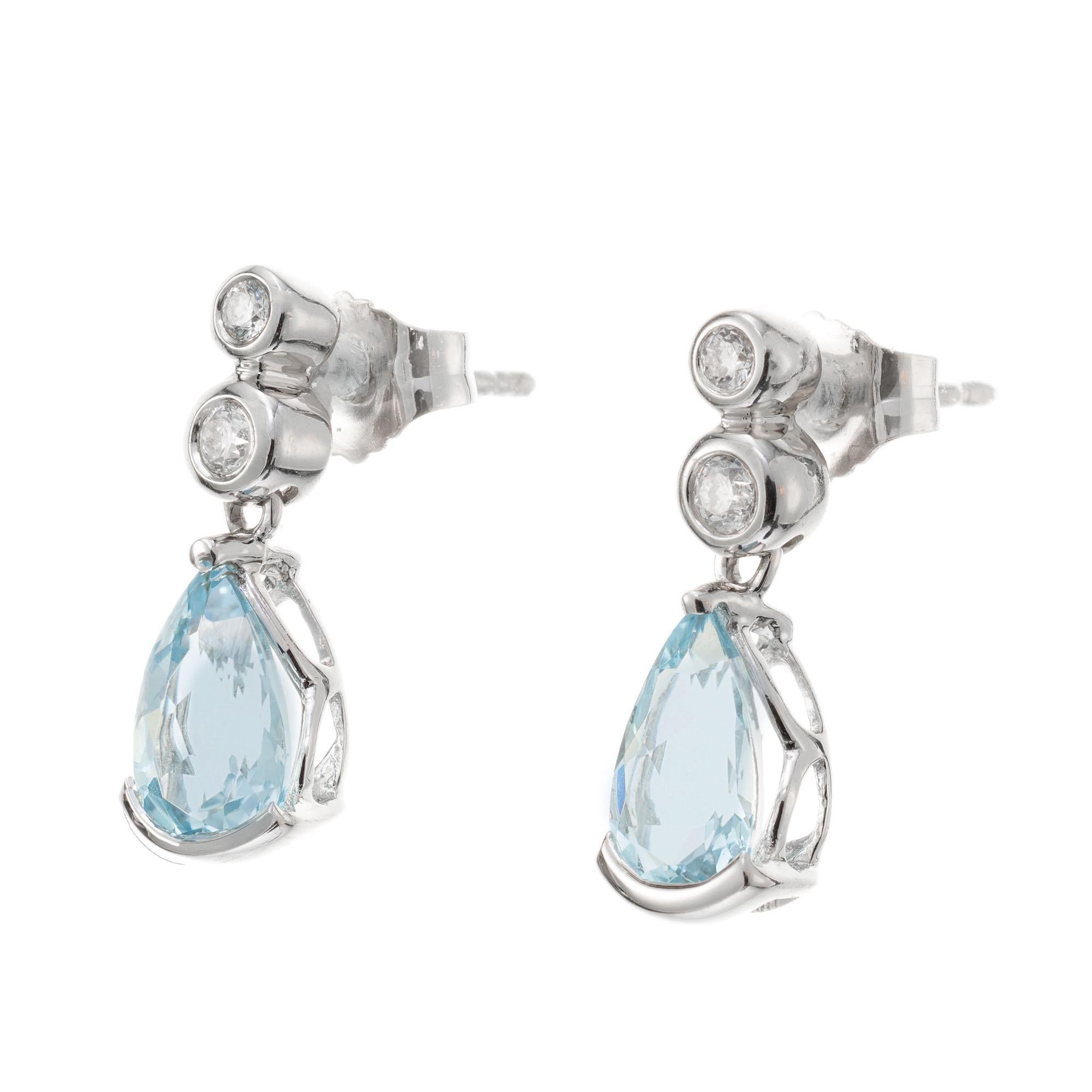 Pear-shaped aquamarine dangles with 4 round brilliant cut accent diamonds set in 14k white gold.  

2 pear shaped light greenish blue aquamarines, approx. 1.00ct
4 round brilliant cut diamonds, H-I VS2 approx. .18cts
14k white gold
Stamped: 14k
2.0