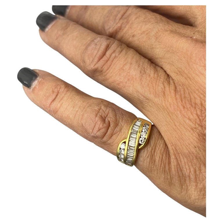 Baguette Diamond Band is 9.30 mm wide and consists of a center row of baguette diamonds accented by a row of rounds on either side. The diamonds are channel set and set in a quality gold setting made of 14 karat yellow gold.

Diamonds 1.00 carat