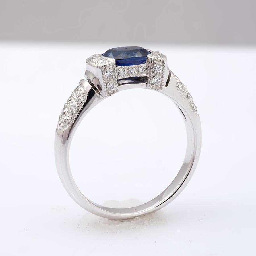 This 1.00 carat Sri Lankan Sapphire, adorned with diamonds on either end, exudes an unmatched vivid blue hue. The oval cut, brilliantly executed, showcases an even distribution of this natural color, greatly enhancing its value. Set in an 18K white