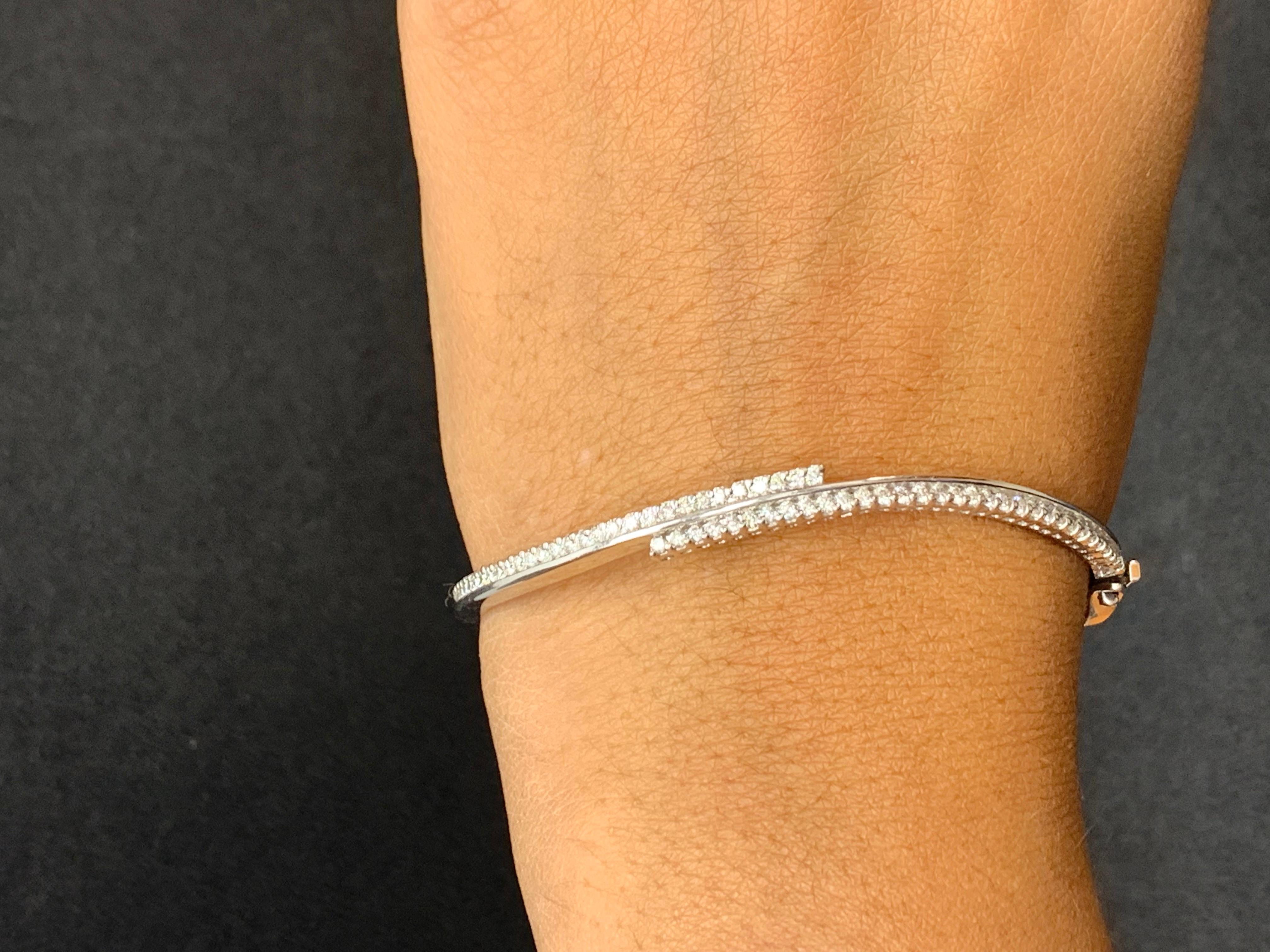 This beautiful Diamond bangle features 64 brilliant-cut round diamonds weighing around 1.00 carats total.  The bracelet has a curved design. Made in 14k white gold. Perfect for a cocktail party.