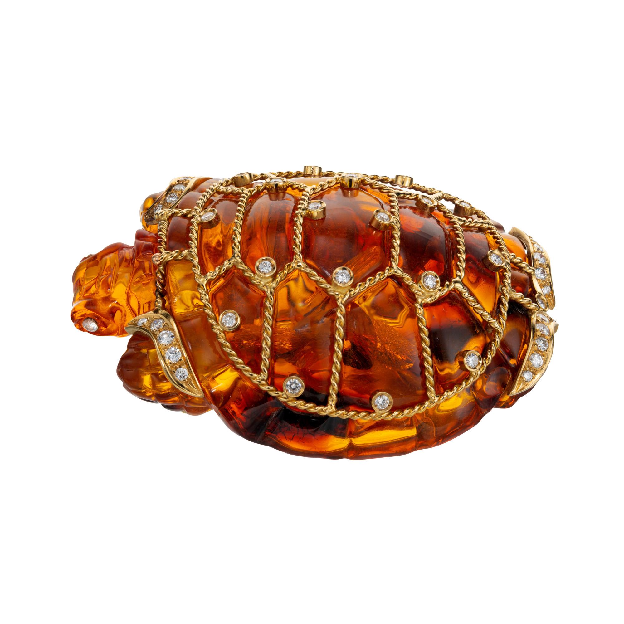 Unique, richly colored large carved amber turtle brooch. This carved amber turtle is decorated with an 18k yellow gold twisted wire framing, accented with 43 brilliant cut bezel and free style diamonds. Secure double pin catch.

1 carved fine amber