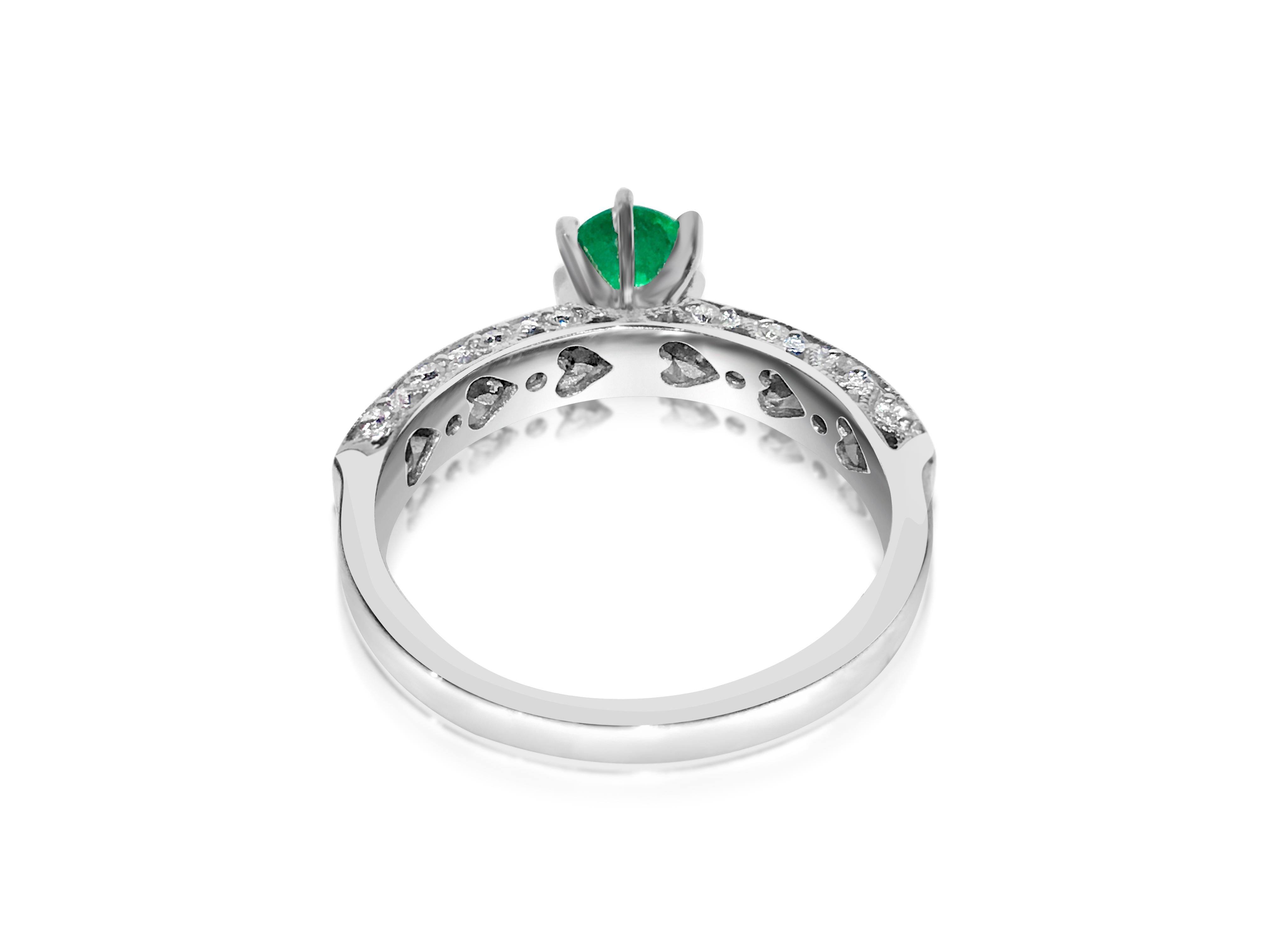 Fashioned from elegant 14k white gold, this captivating ring features a stunning 0.50 carat Colombian emerald, renowned for its rich green hue. Surrounding the emerald are sparkling 0.50 carat diamonds, boasting VS clarity and G color, adding