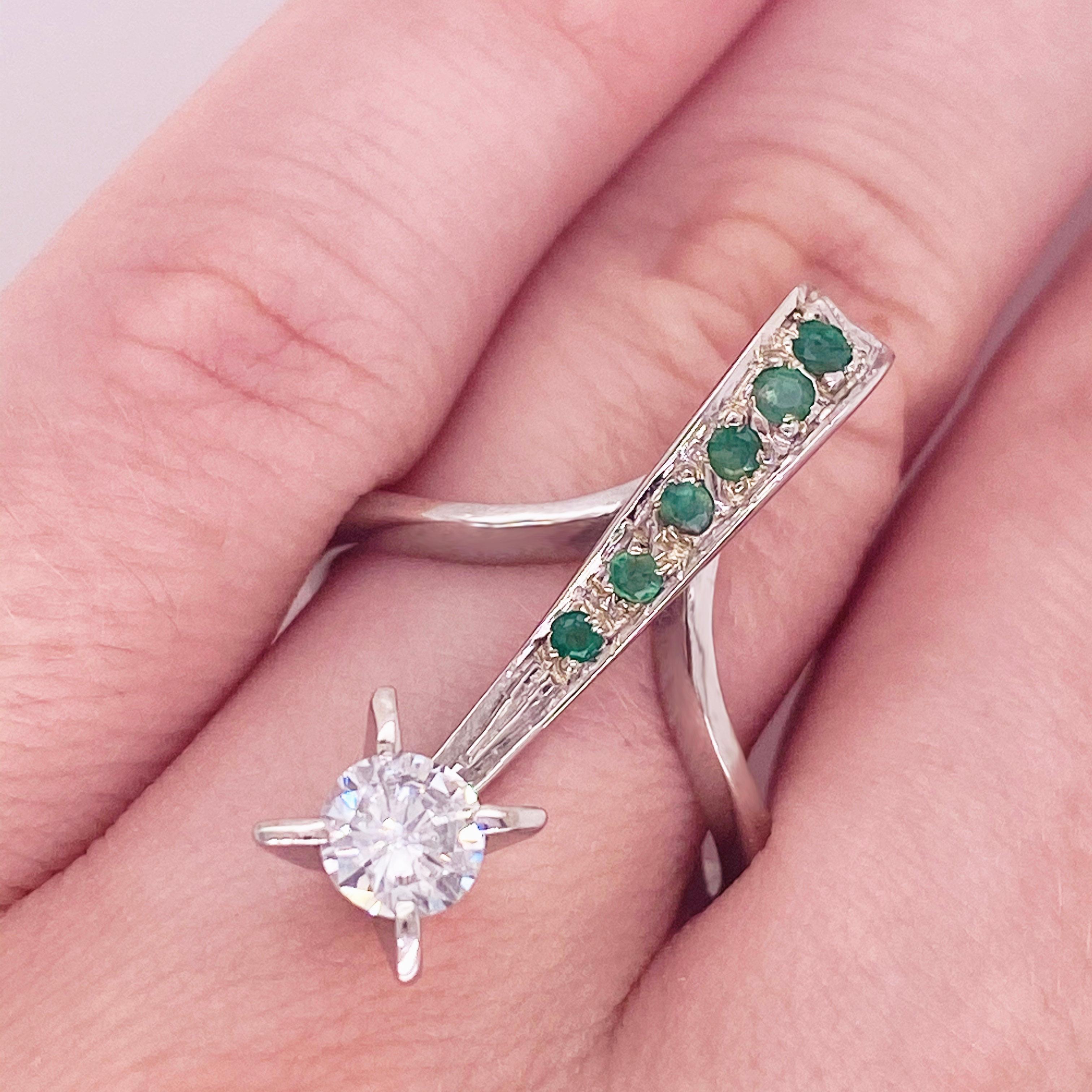 You have never seen anything like this before! This gorgeous freeform ring covered in emeralds and showcasing a stunning white diamond is sure to be a showstopper and a conversation starter. Its beautiful curved design elegantly elongates the finger