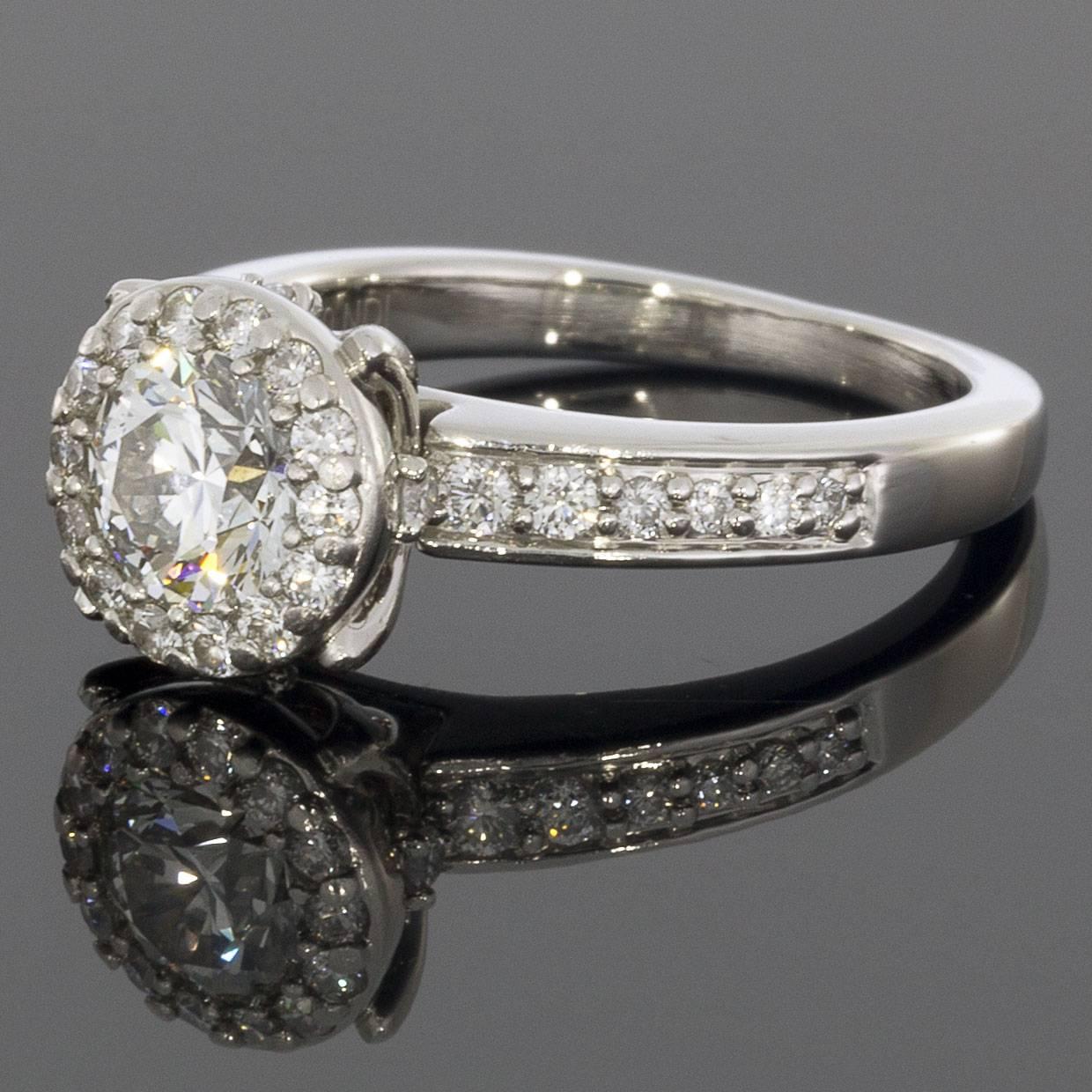  Take her breath away with this absolutely stunning round halo engagement ring. The .70 carat round-shaped center diamond grades as I/VS2. The center gemstone is surrounded by a sparkling halo of round diamonds, which also run down the ring's shank.