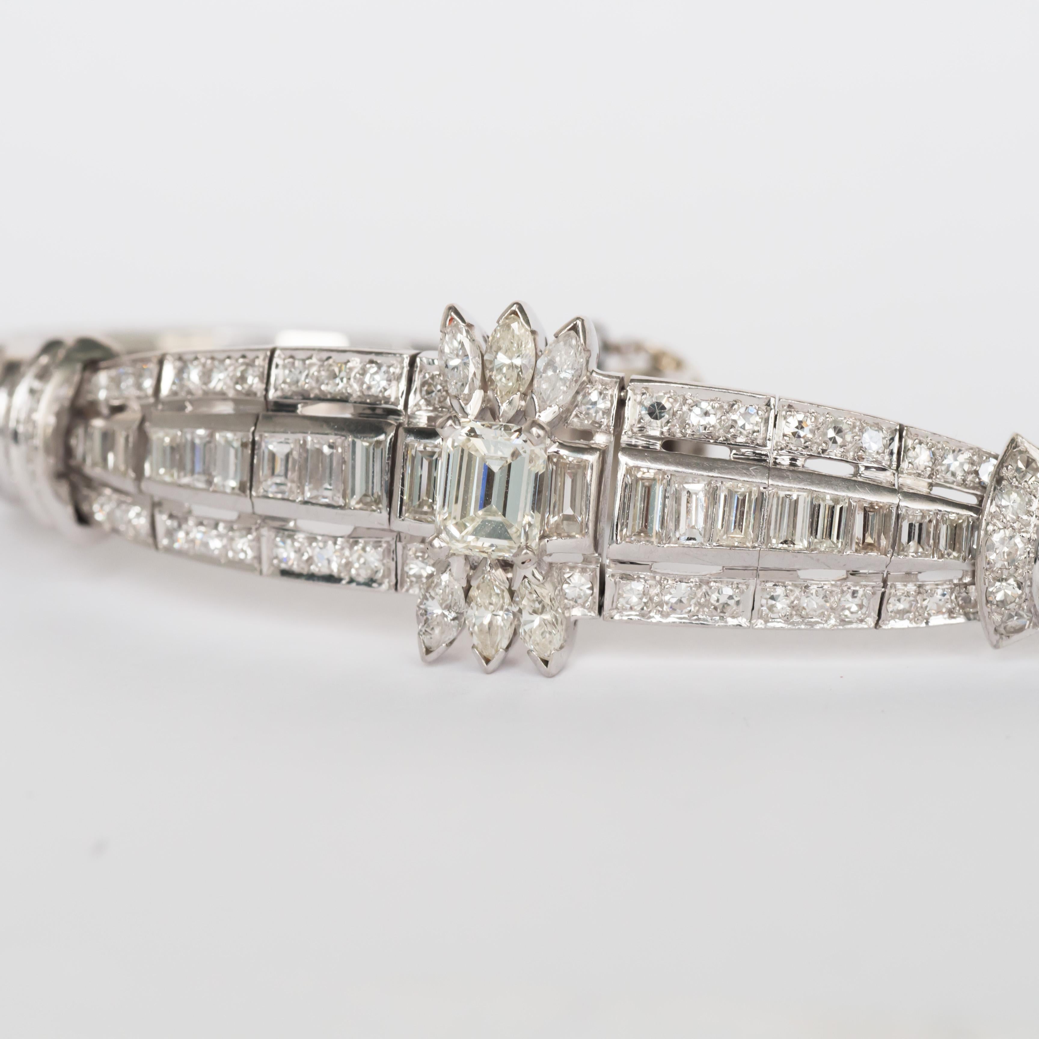 Metal Type: Platinum  [Hallmarked, and Tested]
Weight: 32.5 grams

Center Diamond Details:
Weight: 1.00 carat
Cut: Vintage Emerald Cut
Color: J  
Clarity: VS1

Side Diamond Details:
Weight: 6.00 carat, total weight
Cut: Antique Baguette,