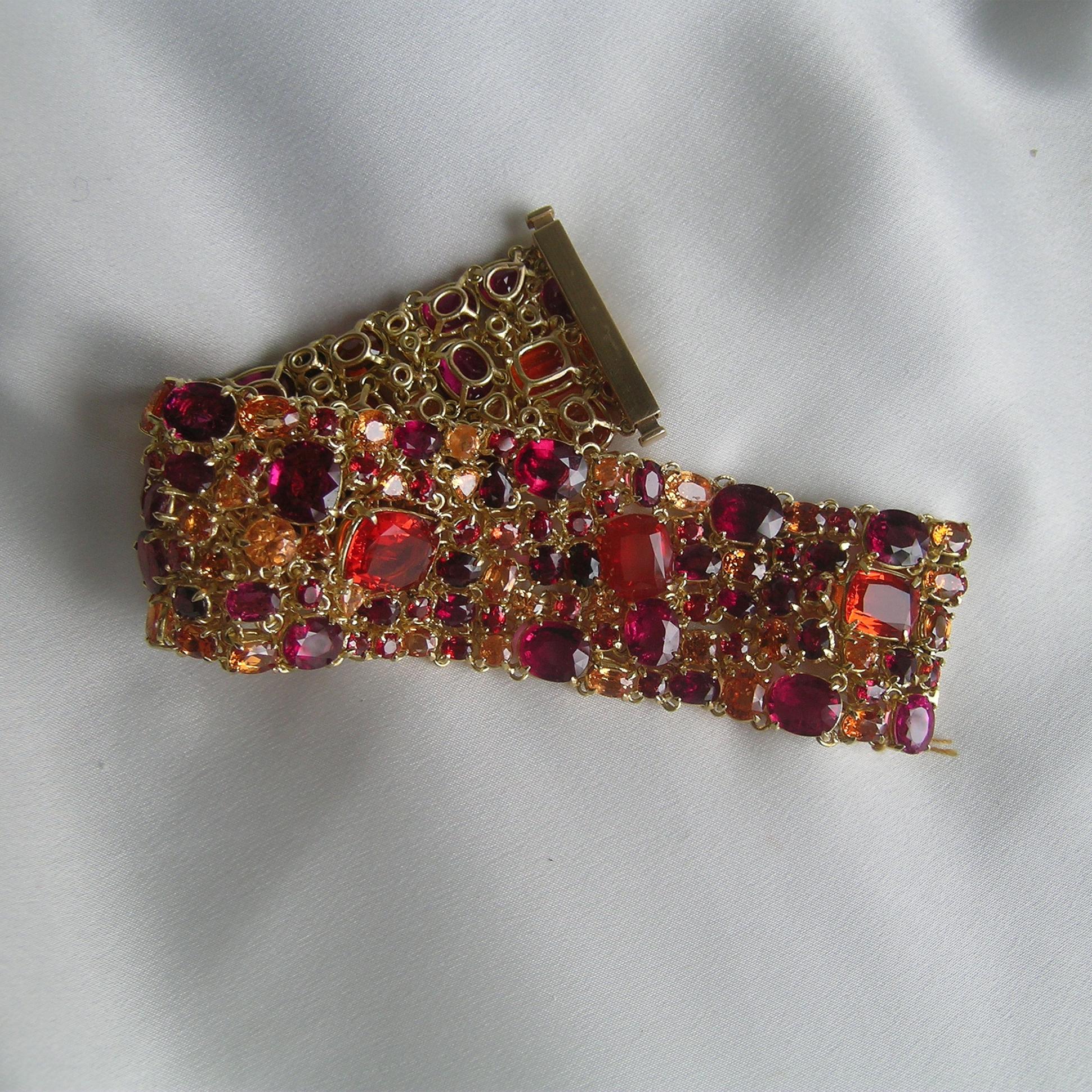 Over 100 carats of Fire Opals, Red Sapphires, Spessartite Garnets, Rubelite Tourmaline are used to make this bold, statement piece.  Set in 18k Gold, this item is hand made and takes over two months to construct.
It is comfortable and fits like a