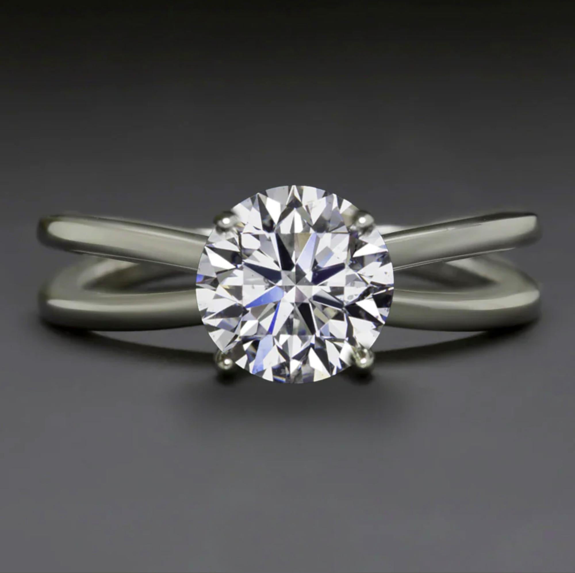 Presenting an exquisite engagement ring that seamlessly blends classic elegance with contemporary design. At its heart lies a GIA-certified 1.00 carat round brilliant cut natural diamond, renowned for its exceptional brilliance and timeless