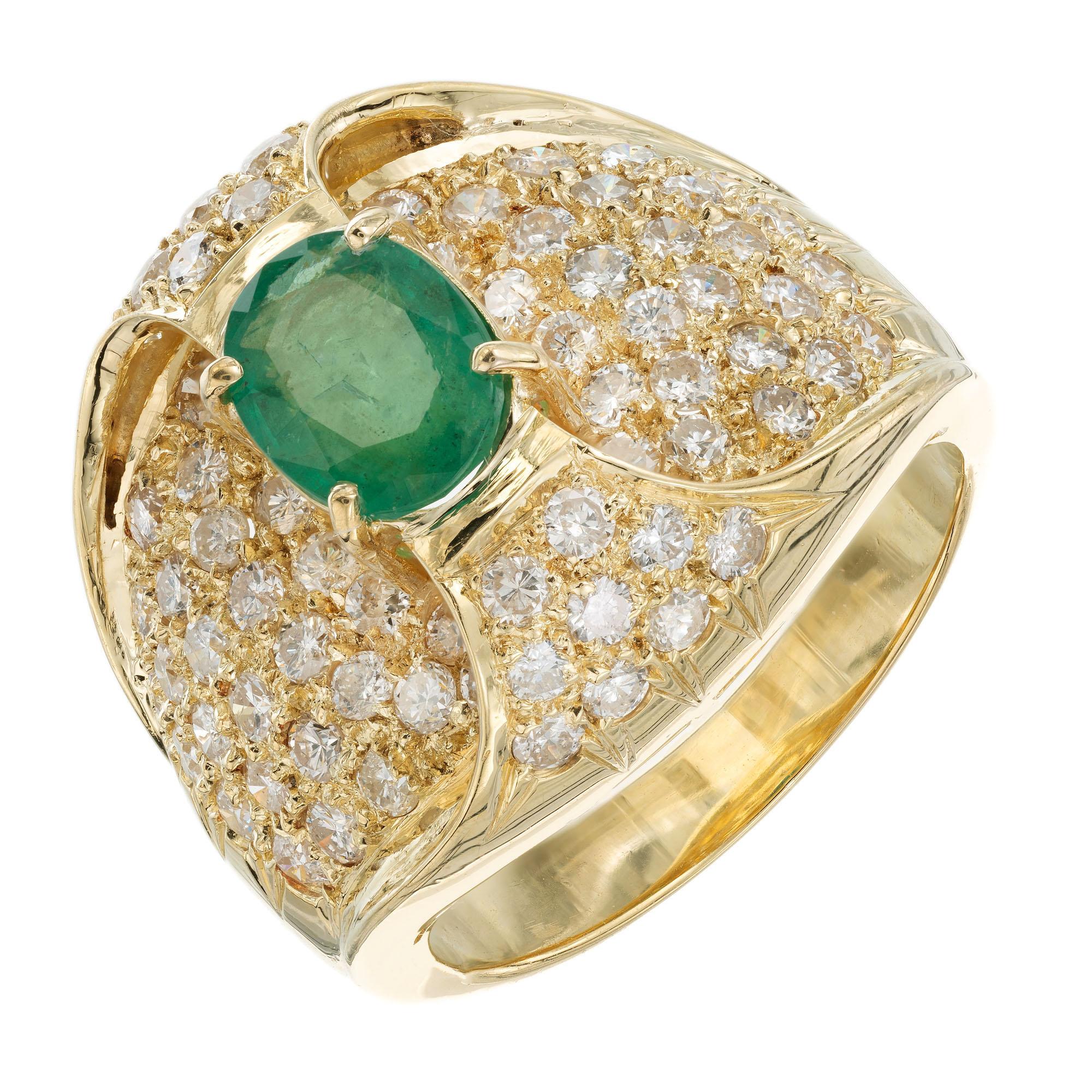 1970’s emerald and diamond cluster cocktail ring. 1.00ct oval emerald center stone set in 18k yellow gold with a cluster of 78 round brilliant cut pave set diamonds. 

1 oval green emerald, MI approx. 1.00
78 round brilliant cut diamonds, G-H SI2-I