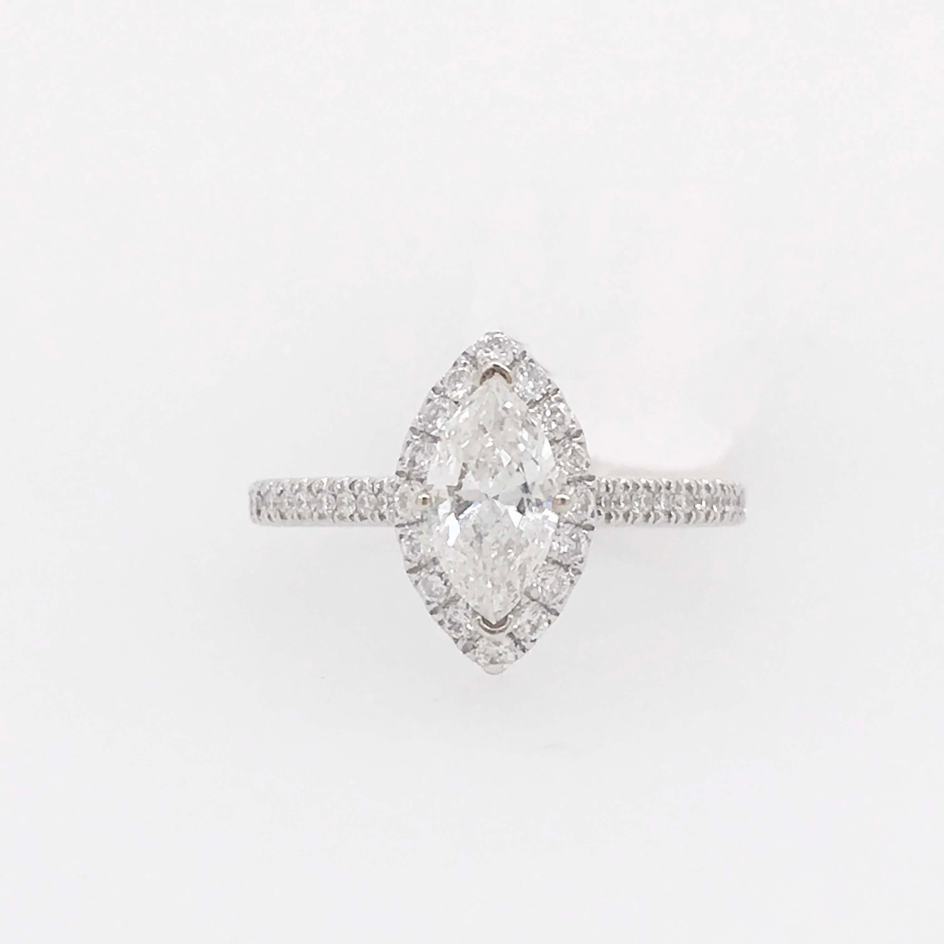 A beautiful diamond engagement ring with a .60 carat marquise diamond and .35 carat diamond halo. The center diamond is a beautiful marquise shape with a bright white F color grade and an eye clean SI-1 clarity grade. The marquise shaped halo frames