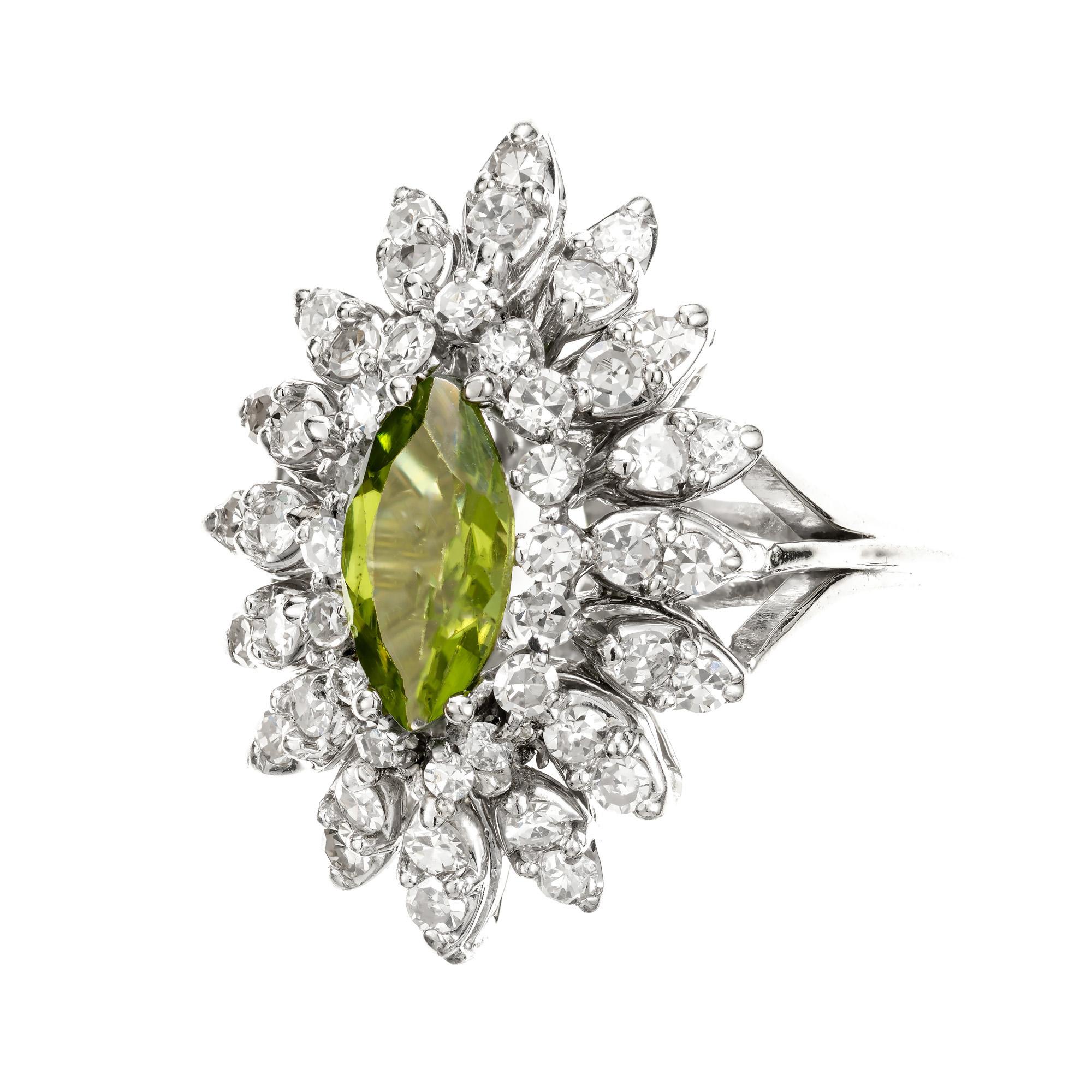 1960’s Mid-Century Peridot and diamond cluster ring. 1.00ct Marquise center stone, set in a 14k white gold cocktail setting with 3 tiers of 48 round single cut diamonds.

1 Marquise medium green Peridot, approx. total weight 1.00cts, VS
48 round