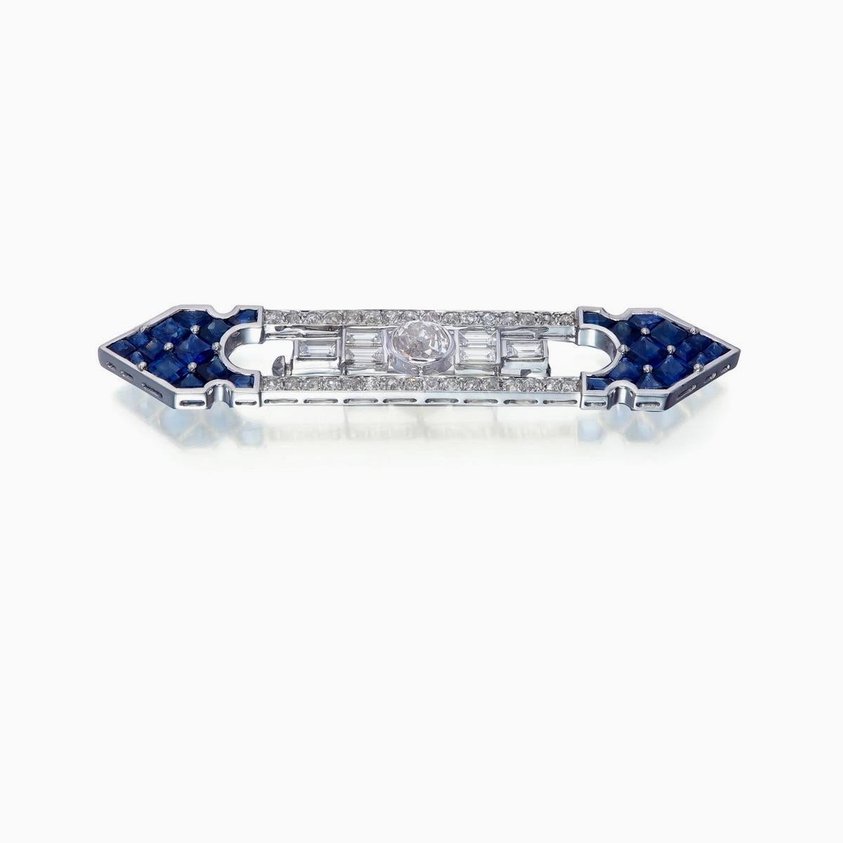 Diese Brosche aus REWA zeigt in der Mitte einen Diamanten im Altschliff mit einem Gewicht von etwa 1,00 Karat. 
Außerdem ist er von 6 Diamantbaguetten mit einem Gewicht von ca. 0,80 Karat und 32 runden Diamanten mit einem Gewicht von ca. 0,87 Karat