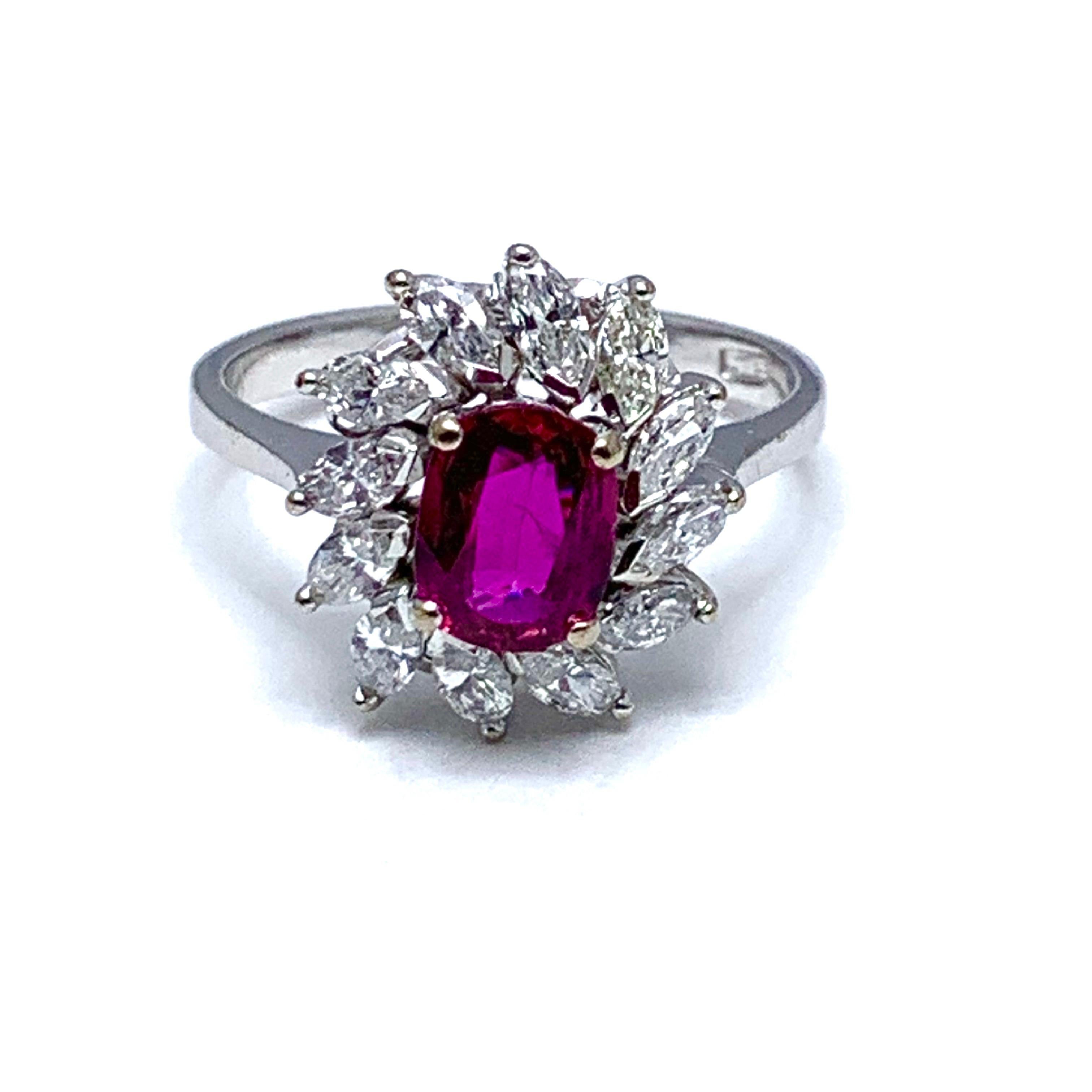 A vibrant currant red 1.00 carat Ruby and marquise Diamond engagement/cocktail ring in 14 karat white gold.  The Ruby is uniquely set slightly off center in conjunction with the slant set marquise Diamonds.  The 12 Diamonds have a total carat weight