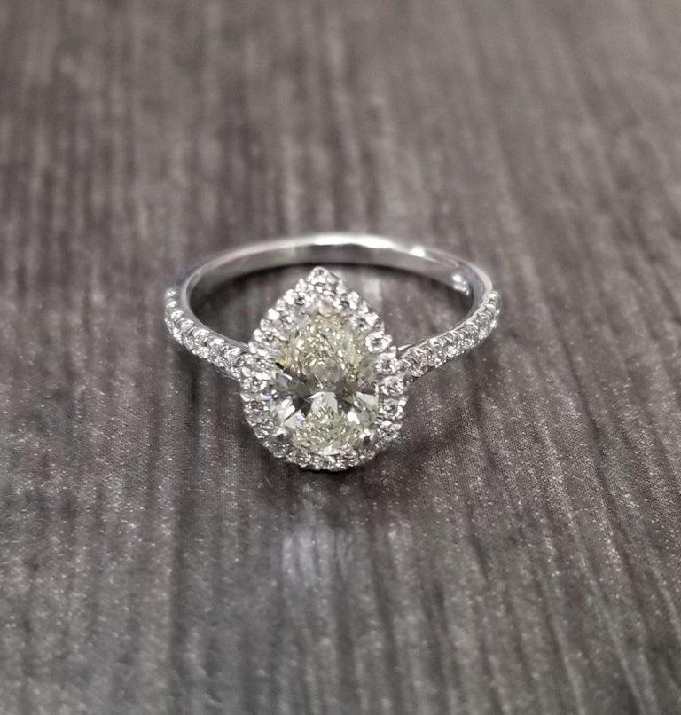 14k white gold ladies diamond ring, containing 1 pear shape diamond weighing 1.00cts. and 36 round full cut diamonds of very fine quality weighing .27pts.