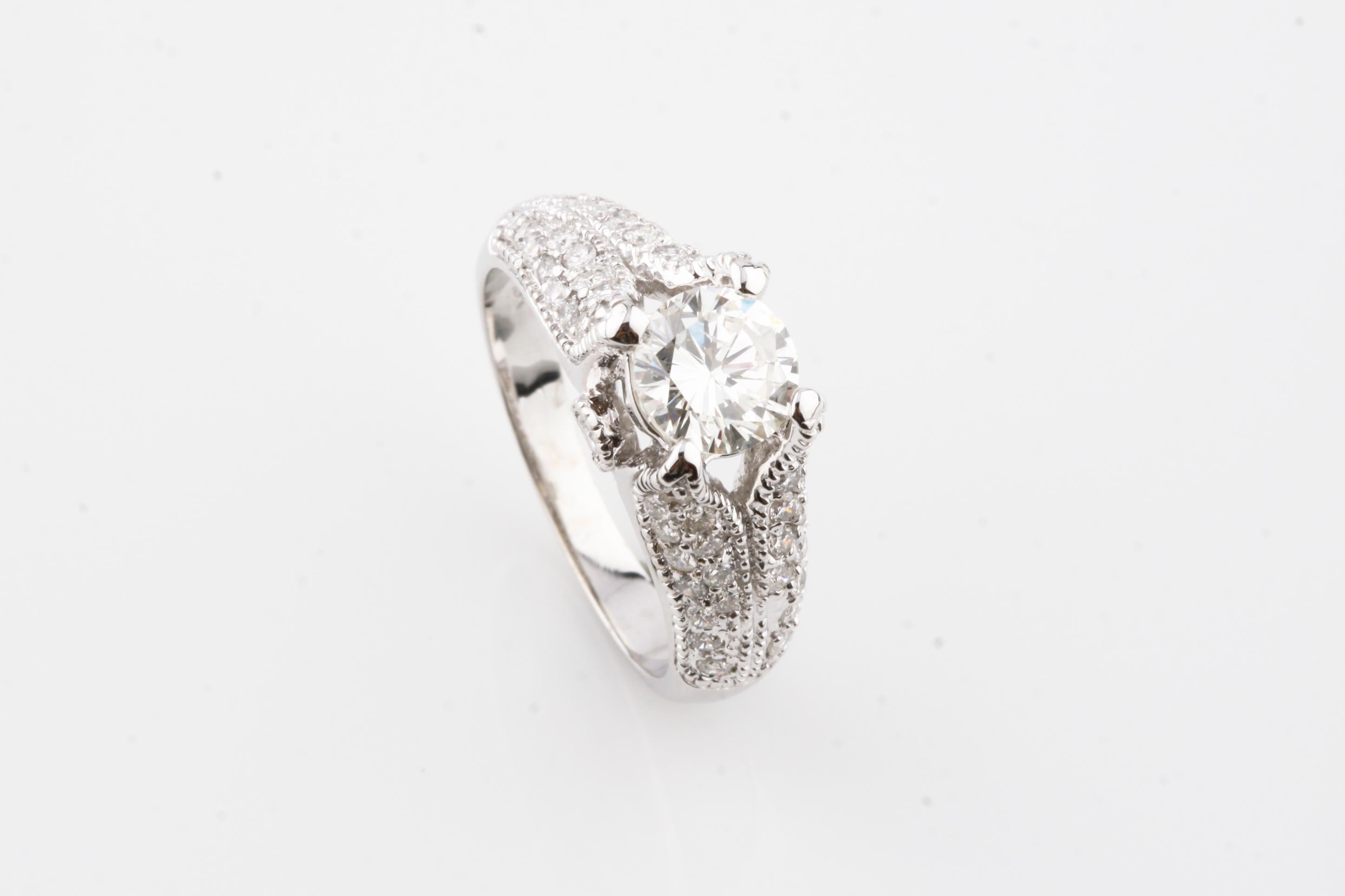 One electronically tested 18KT white gold ladies cast diamond unity ring.
Condition is good.
Featuring a diamond solitaire set within a gallery of diamonds, supported by diamond set shoulders
Completed by a three millimeter wide band.
Identified