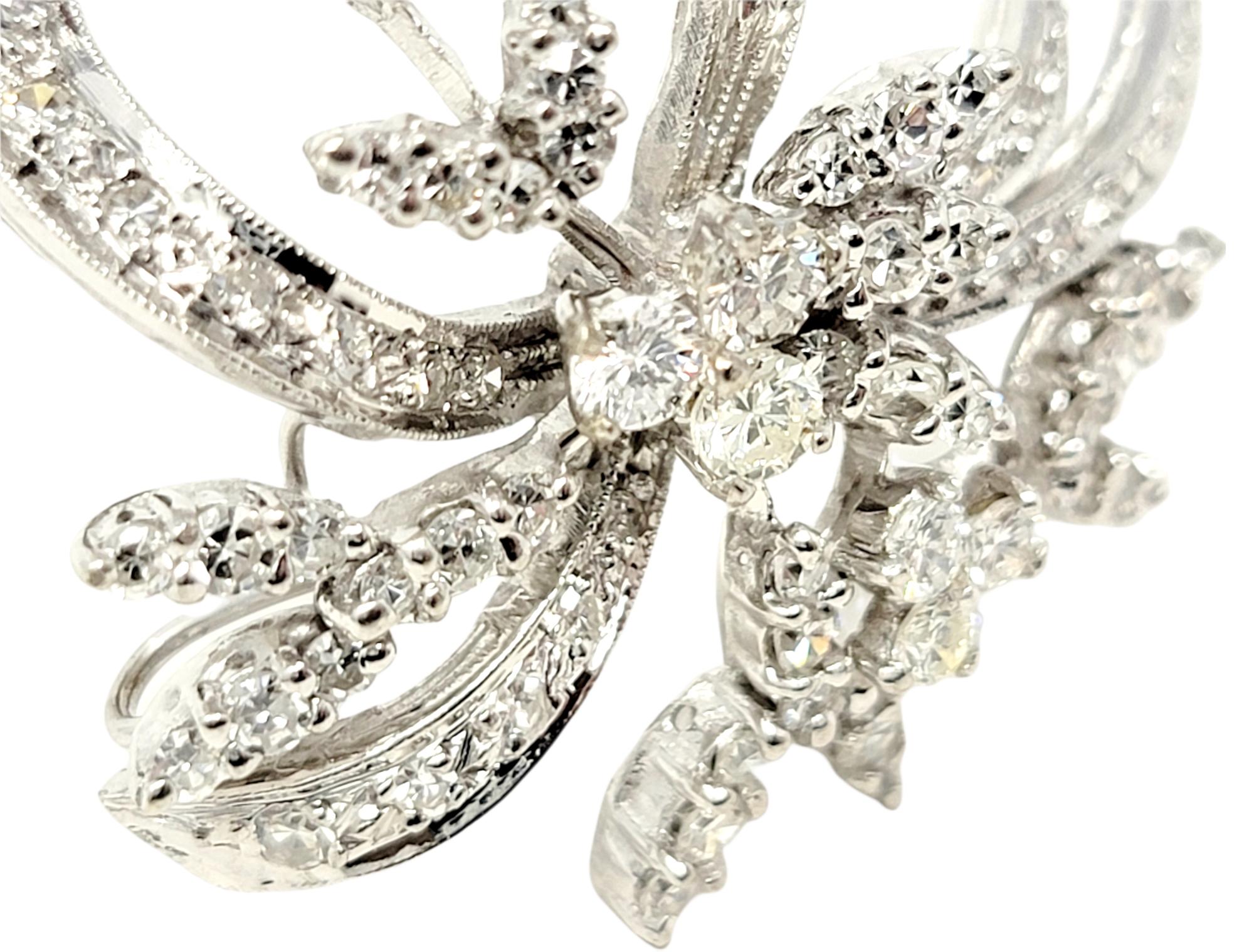 Elegant vintage style brooch bursting with sparkle. This gorgeous brooch is made of 14 karat white gold and arranged in a horizontal layout. It features 78 icy white natural round brilliant and single cut diamonds set in a sophisticated swirling