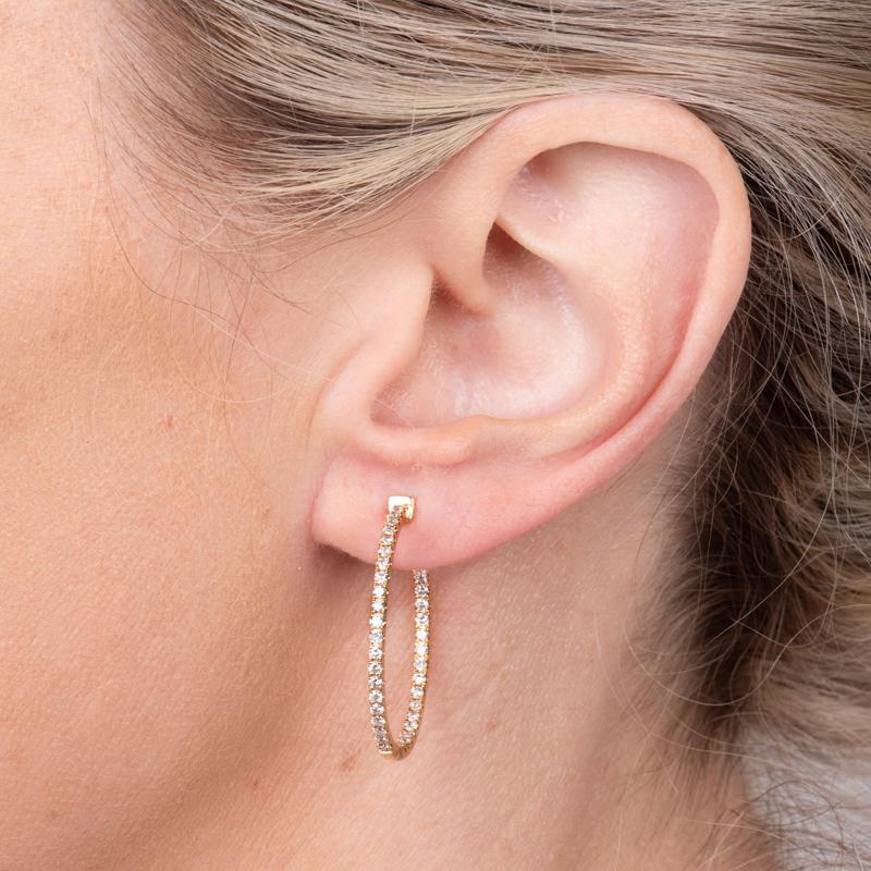 These inside out hoop earrings feature 1.00 carat total weight in natural round diamonds set in 14 karat yellow gold. 
Measurements: Inner diameter approximately 25.50mm
