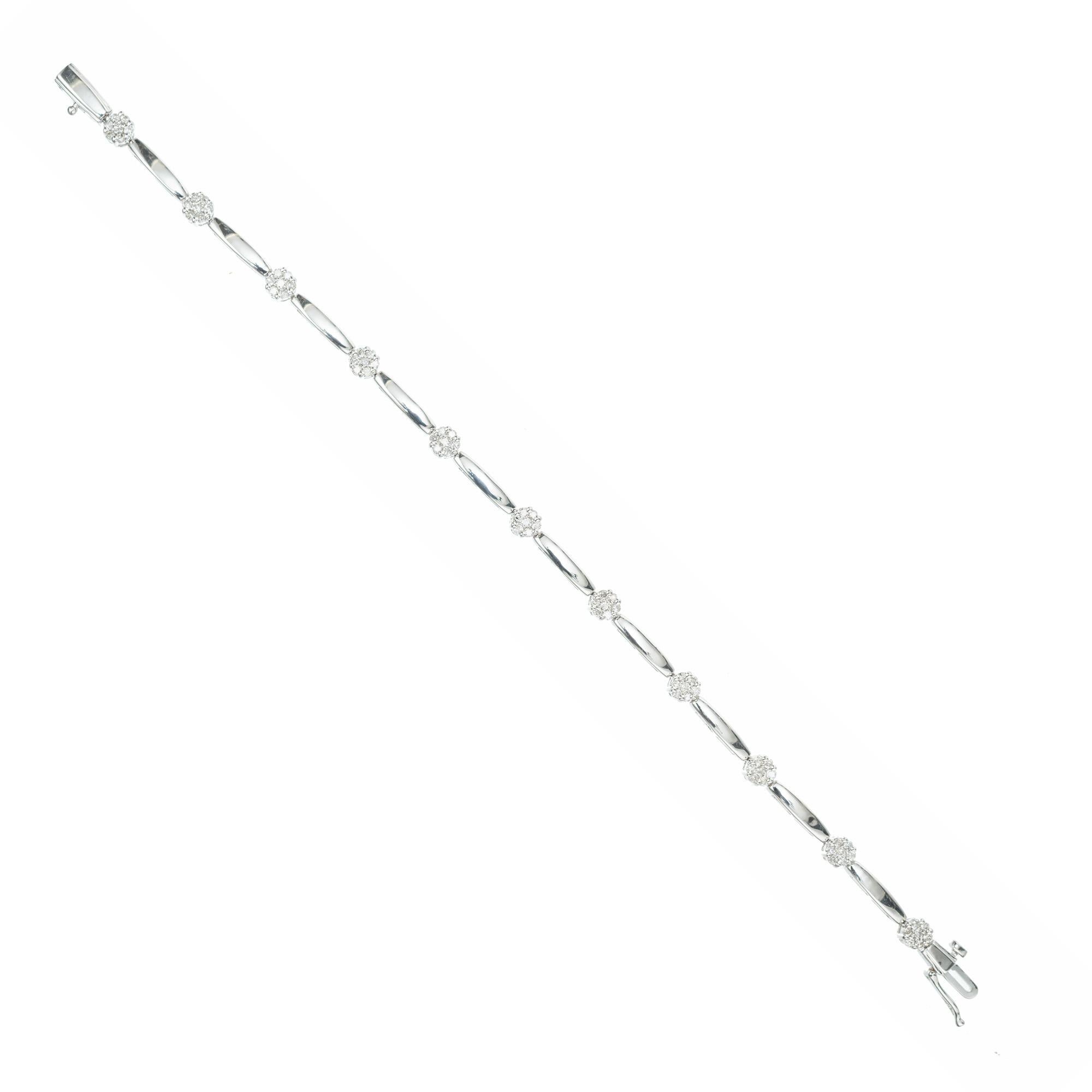 Diamond bracelet. 11 clusters with a total of 77 round cut diamonds set in 14k white gold. Separated by a by white gold bars. 7.25 inches in length. 

77 round cut diamonds. approx. total weight 1.00ct.  I, SI
Stamped: 14k white gold
Weight: 9.3