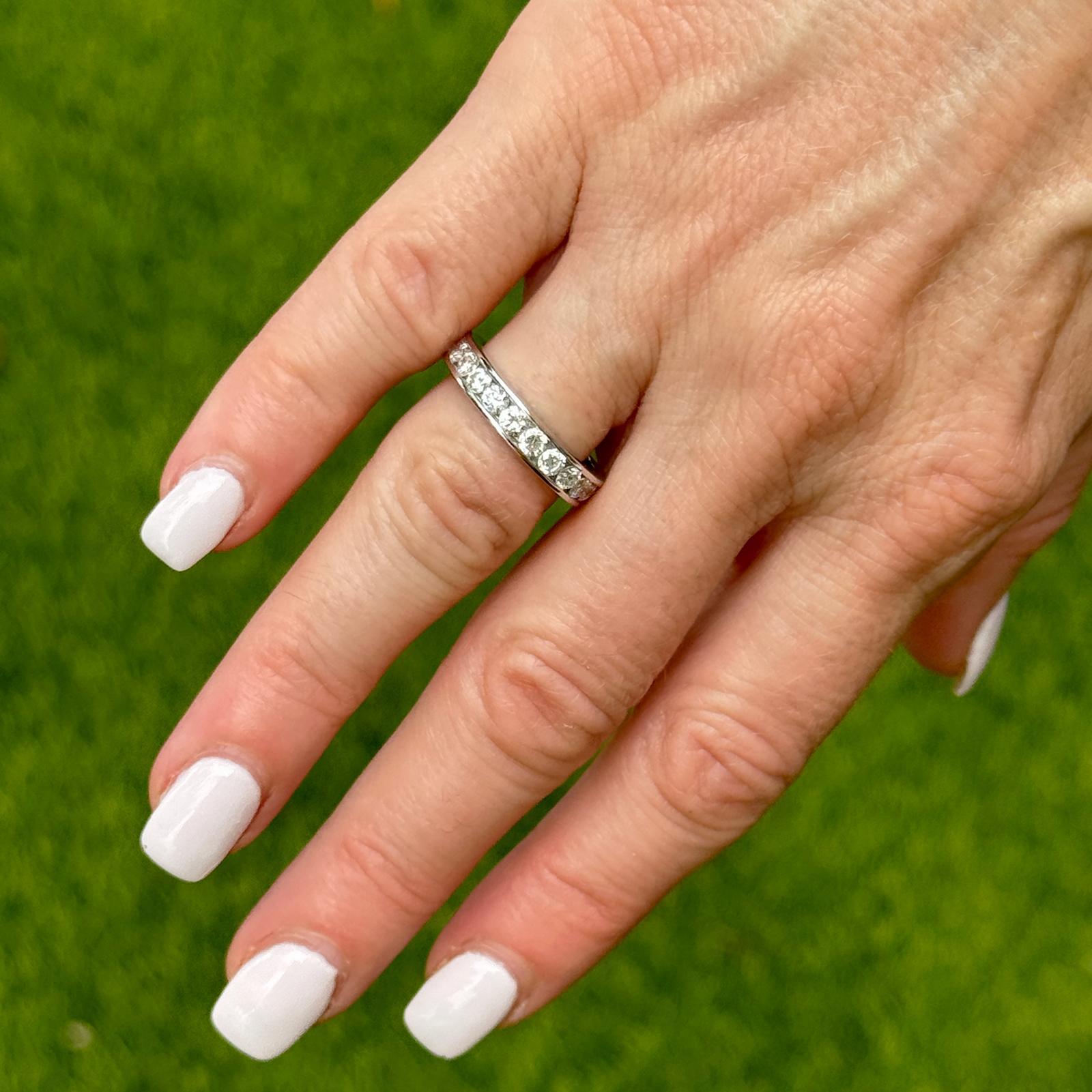 Questa classica fede nuziale in oro bianco da 14 carati con diamanti incastonati a canale presenta un design senza tempo con 12 diamanti rotondi con taglio a brillante, per un totale di 1,00 carati di peso. I diamanti, di colore G-H e di purezza SI,