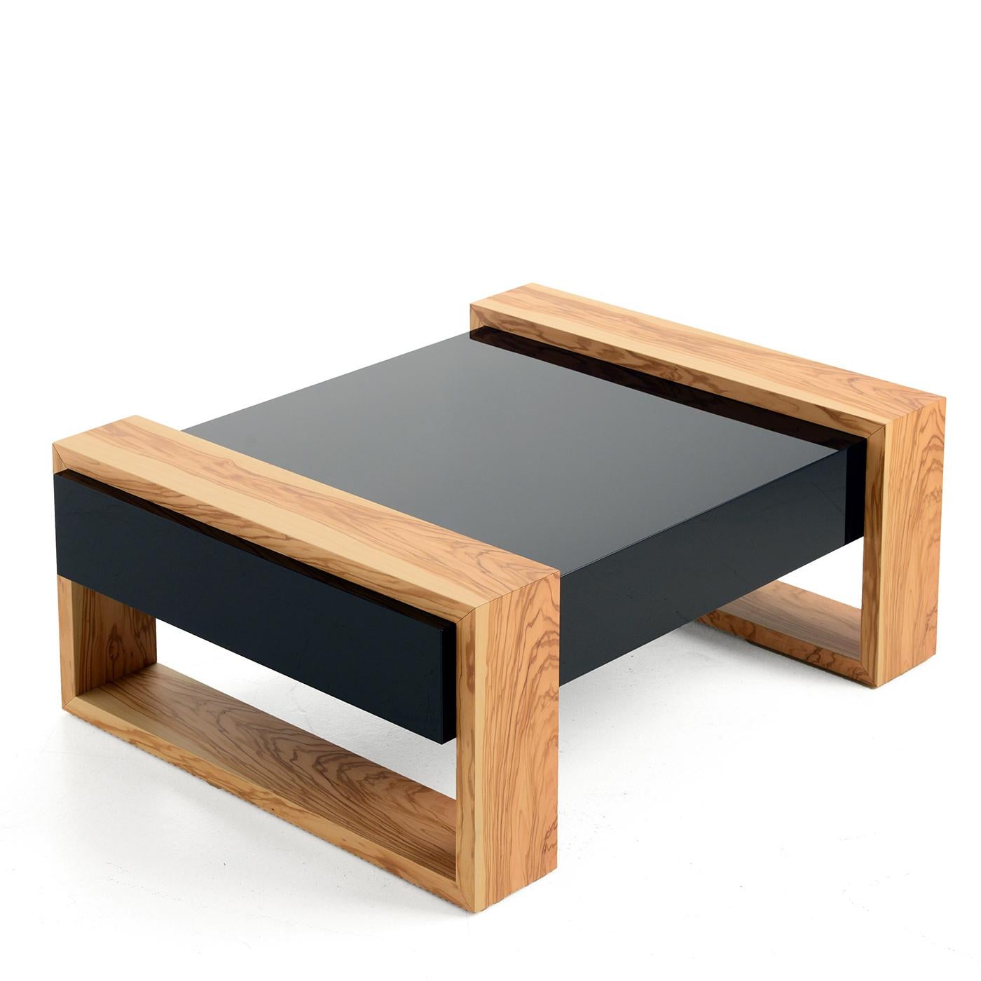 This low coffee table pays homage to the Italian region of Puglia, located in the heel of the country's heel. Its black paraban top represents the darkness of night, while its light olive wood structure symbolizes olive trees glistening under the