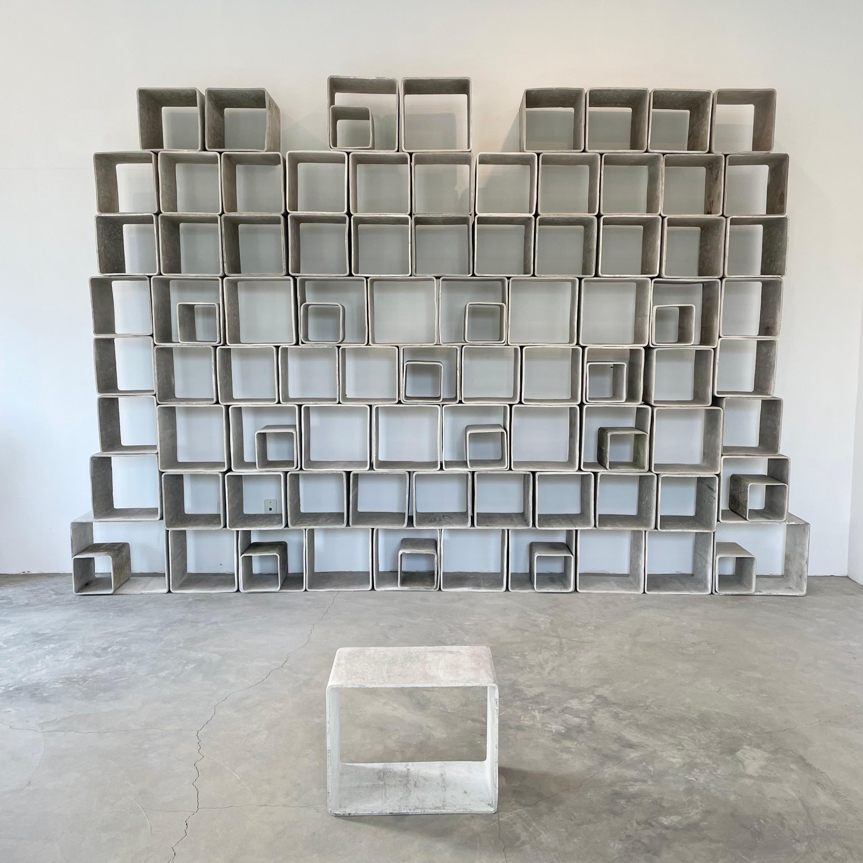 Stunning monumental 100 piece concrete bookcase by Willy Guhl. Made up of 4 different sized hand-made concrete cubes. Completely modular and able to be arranged in a multitude of ways. Original concrete color. Some slight patina or light paint.