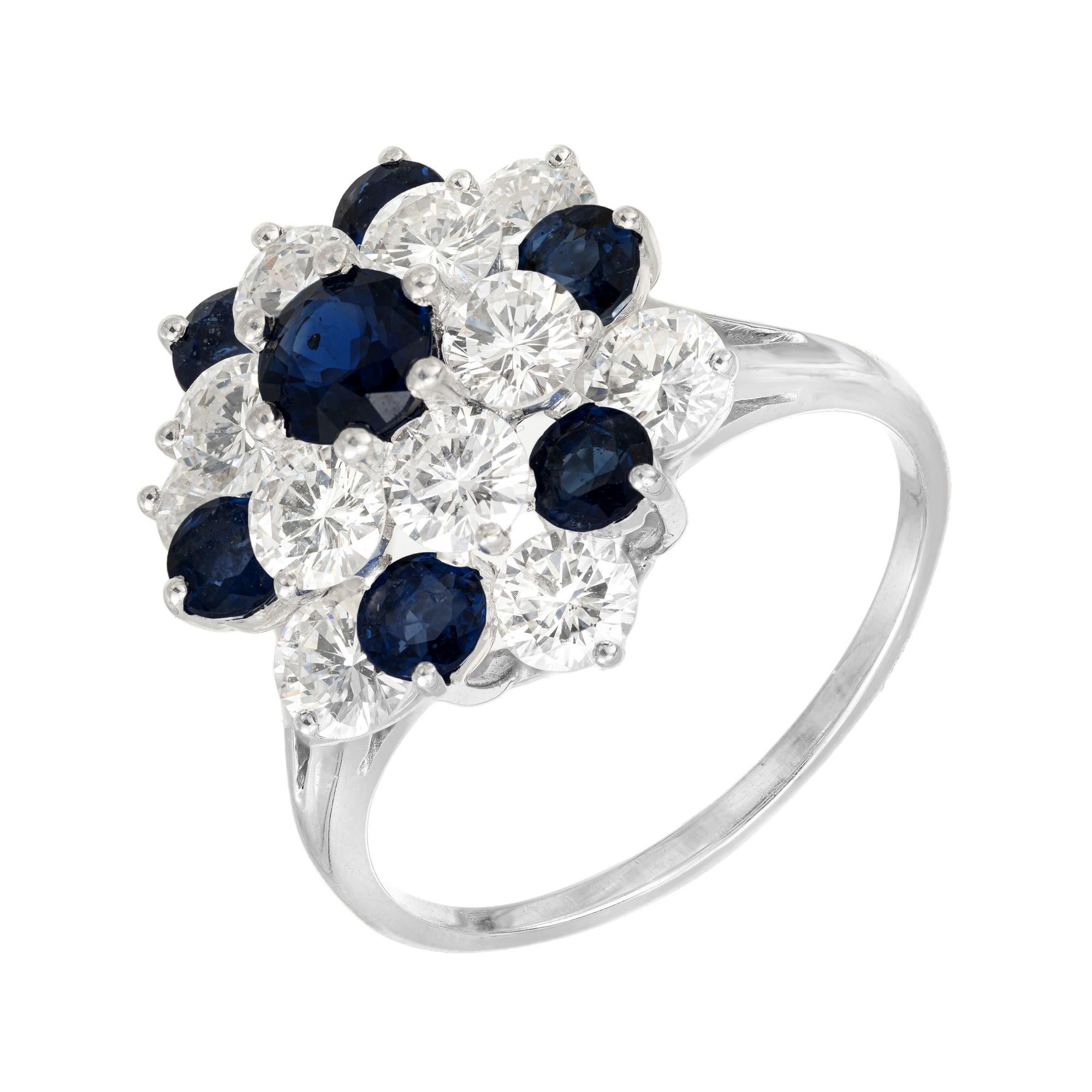 1980's deep blue sapphire and diamond raised cluster ring. This ring is boasts a cluster of 7 round cut blue sapphires with a total approximate weight of 7.00crts, that are accented by 12 round brilliant cut diamonds with an approximate carat weight