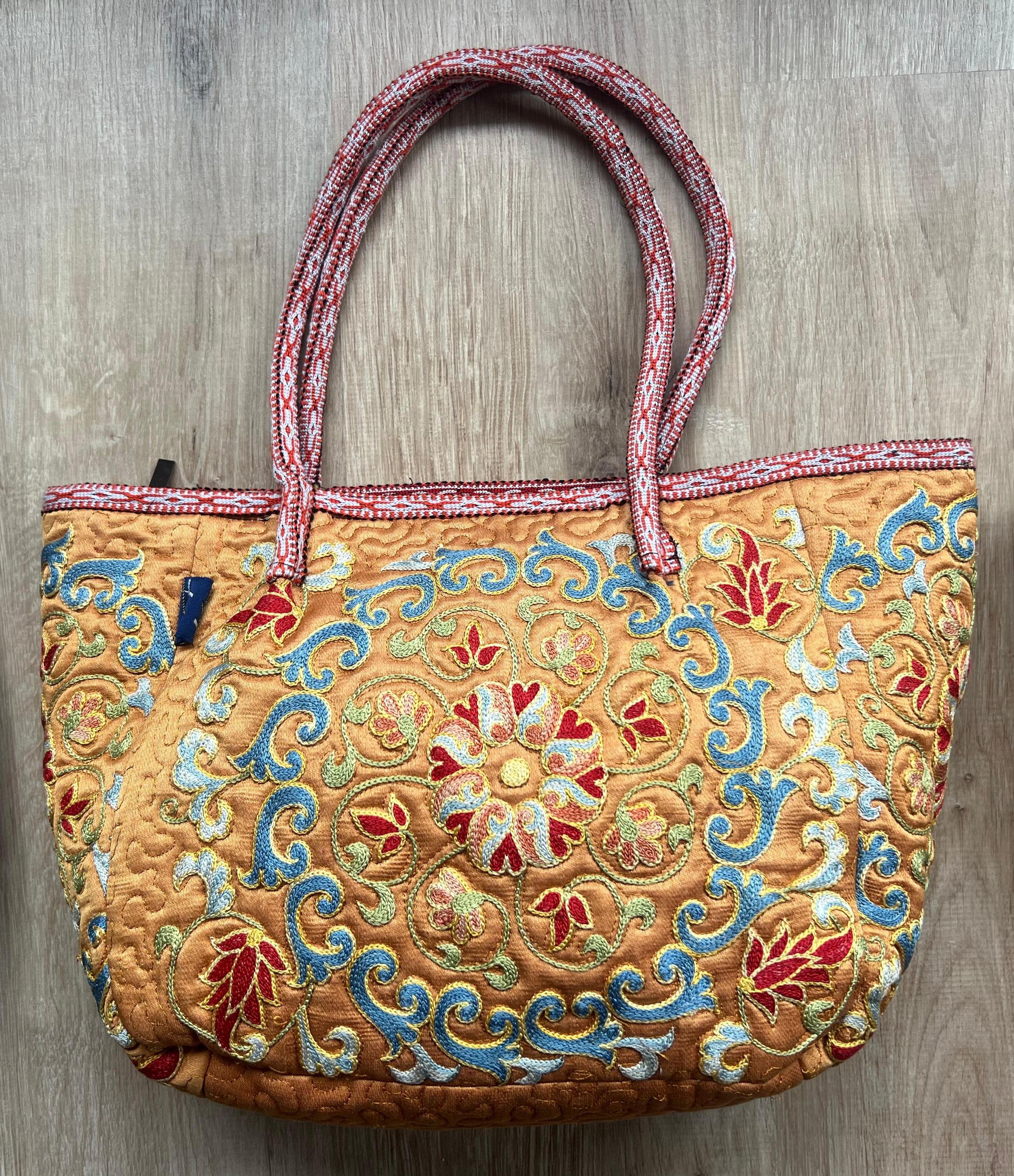 Elevate your style with this exquisite hand-embroidered Suzani handbag, crafted from 100% pure silk. Blending the beauty of traditional Uzbek Suzani embroidery with a modern aesthetic, this bag is a true statement piece for any