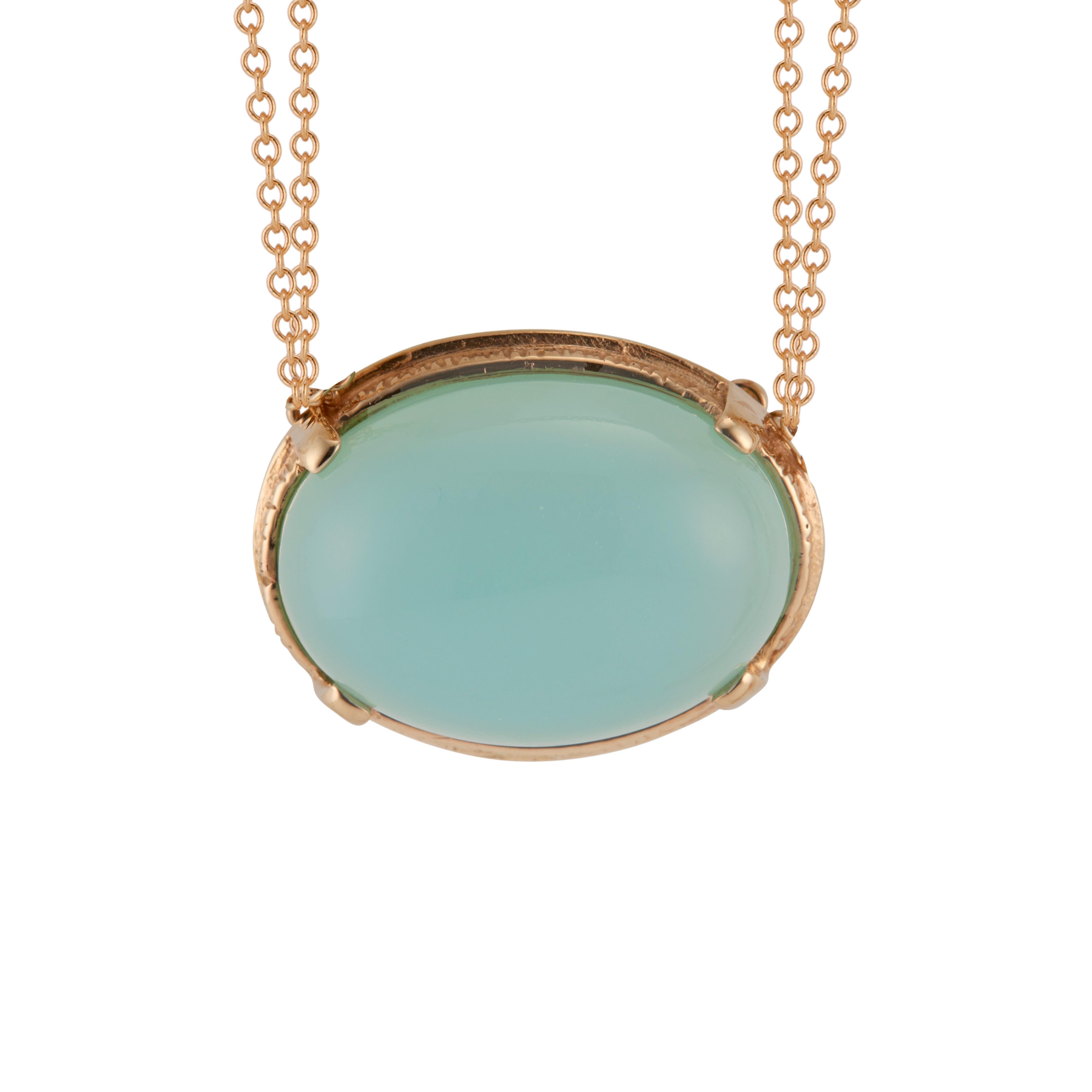 Oval cabochon blue chalcedony pendant necklace. 10.00ct oval blue center chalcedony set in a 14k yellow gold bezel with a 15.5 -16 inch 14k yellow gold double chain. Signed JJ.  

1 oval greenish blue cabochon chalcedony, approx. total weight