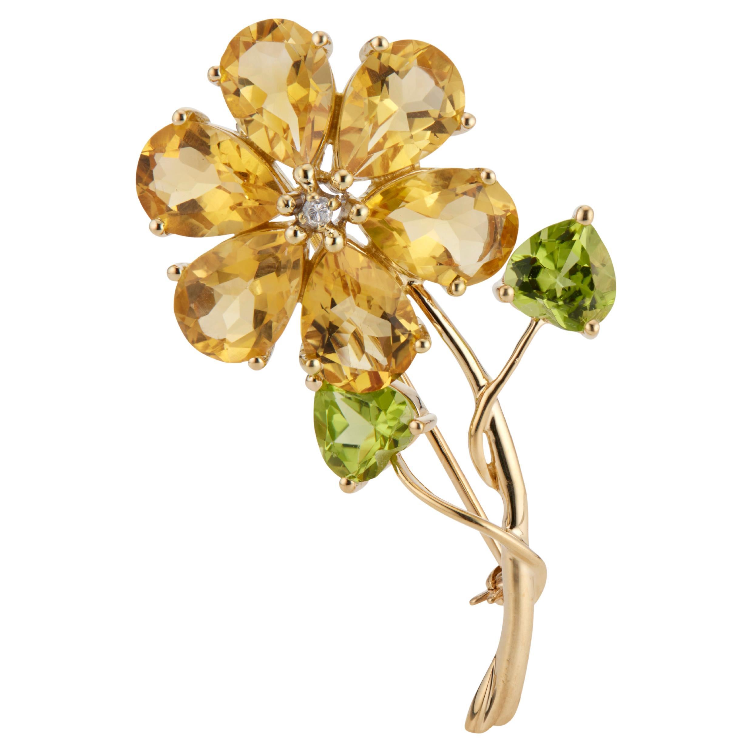 Peridot, diamond and citrine flower brooch. 6 pear shaped citrines with a round diamond center stone set in 14k yellow gold with two heart shaped peridots. 

6 pear shape brownish orange citrines, approx. 10cts
2 heart shape green peridot, approx.