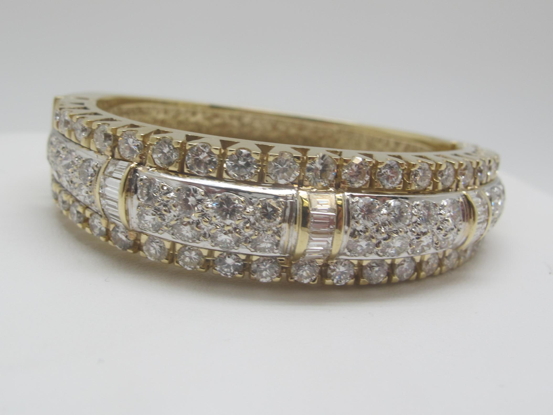 Wow!  This beautiful bangle bracelet packs a punch, set with 70 round brilliant cut  and baguette cut diamonds that total at least 10.00 carats in combined weight.  These diamonds have average color grade 