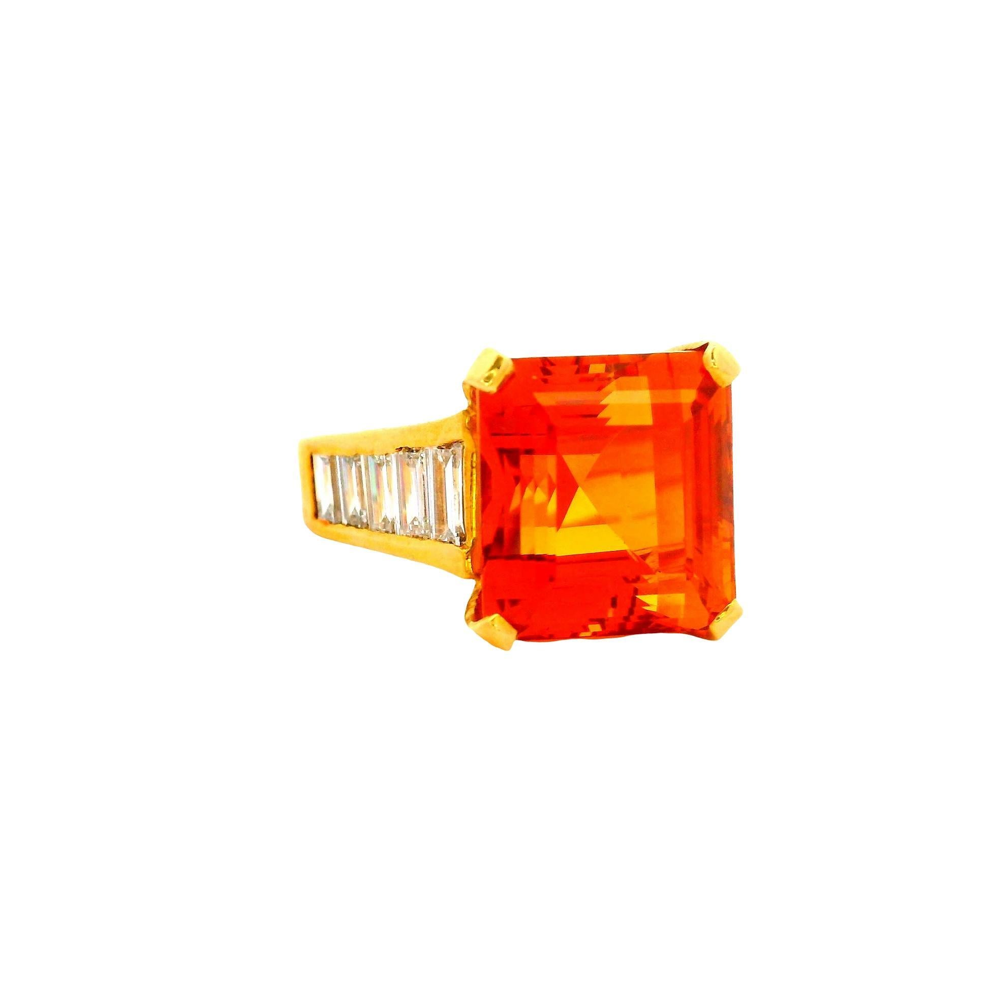 A striking fashion ring featuring a 10.0 carat emerald-cut Imperial Topaz. The vibrant orange hue of the topaz is complemented by 1.5 carats of baguette-cut white diamonds, adding a refined brilliance. Crafted in 18k yellow gold, this piece embodies