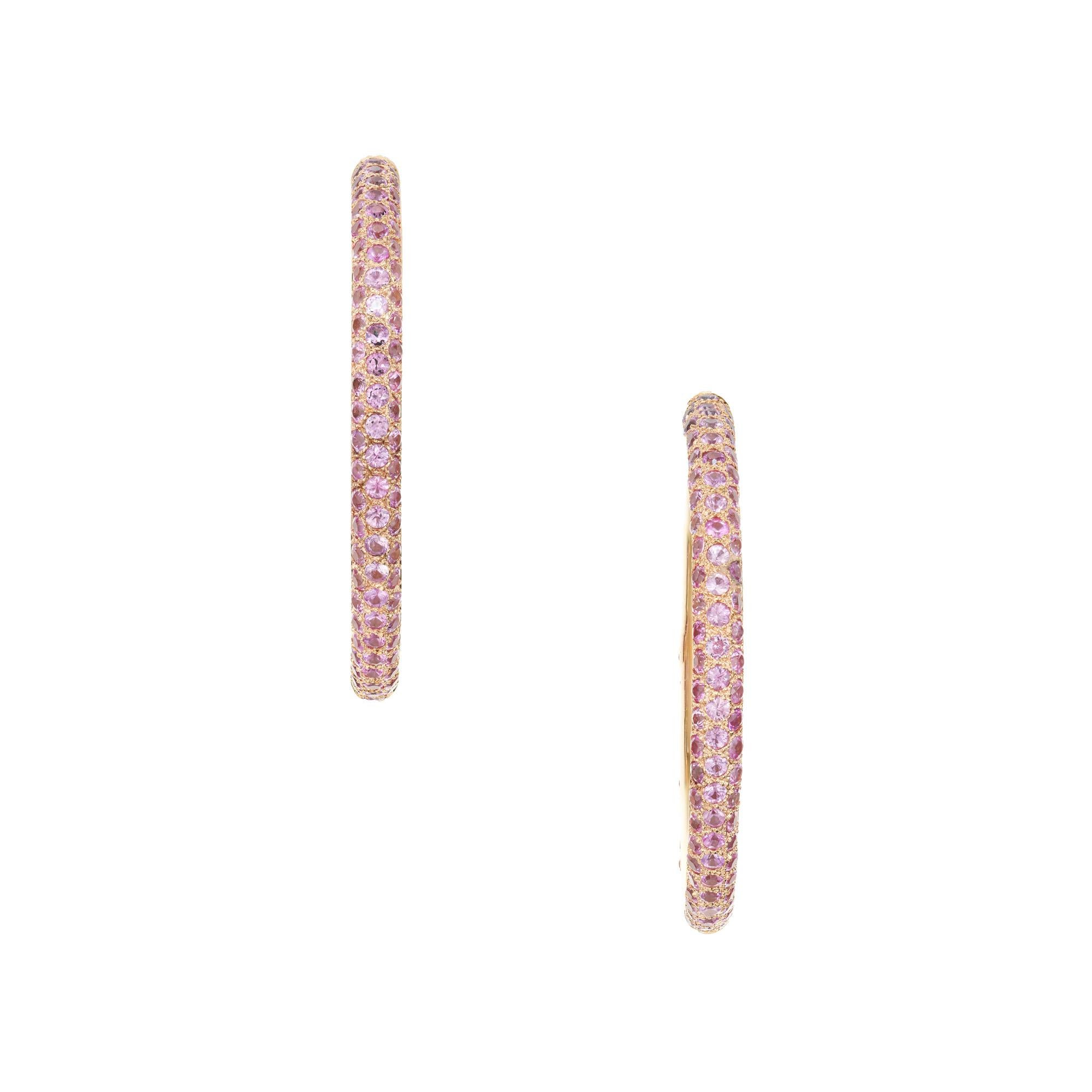 1990's Sapphire hoop earrings. These earrings feature 304 round pink sapphires totaling approximately 10.00cts. set in 18k yellow gold hoops. These magnificent earrings are 1.75 Inches across, 4mm wide.  

304 pink sapphires, SI approx. 10.00cts
18k