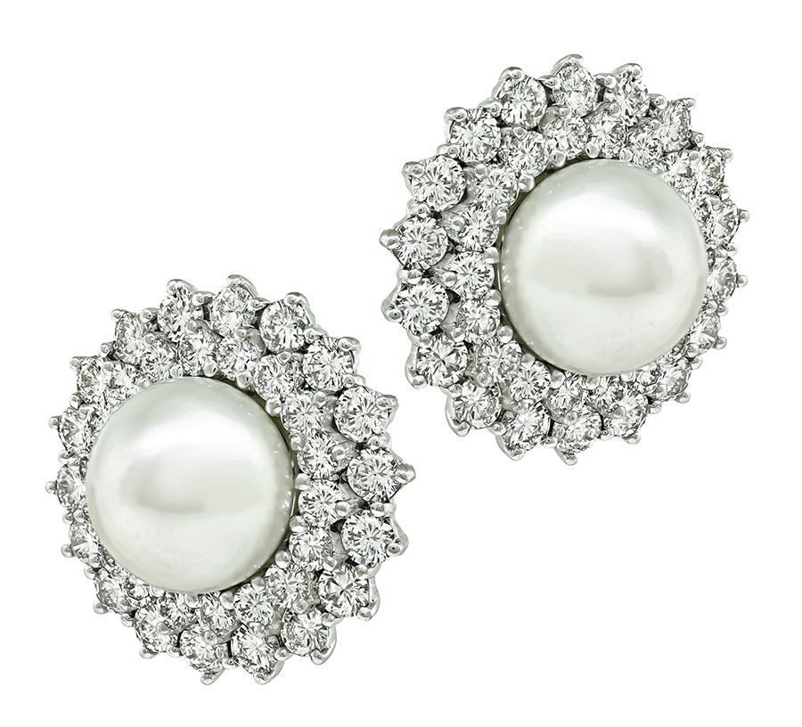 This is a stunning pair of platinum earrings. The earrings feature sparkling round cut diamonds that weigh approximately 10.00ct. The color of these diamonds is E-F with VS clarity. The diamonds are accentuated by lovely cabochon pearls. The