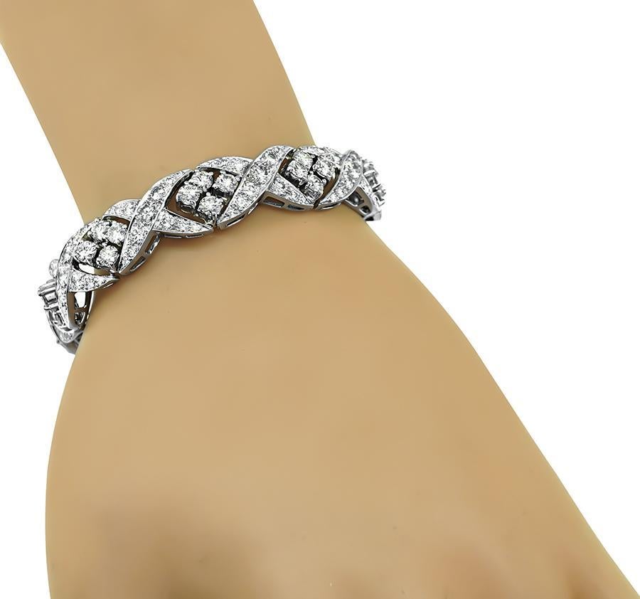 This is an elegant platinum bracelet. The bracelet is set with sparkling round cut diamonds that weigh approximately 10.00ct. The color of the diamonds is G-H with VS clarity. The bracelet measures 7 inches in length and 12mm in width. The bracelet