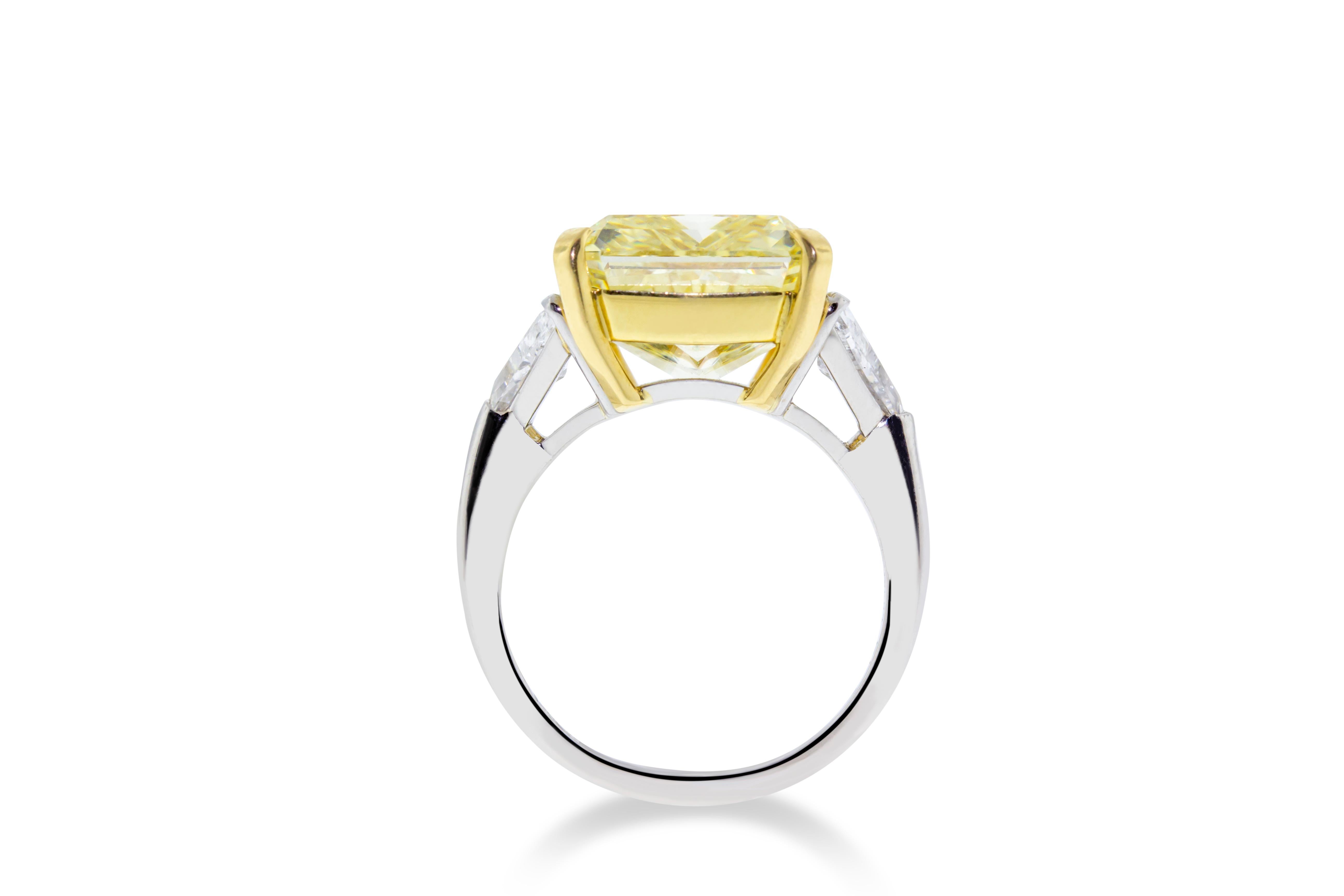 This 10.01 GIA certified VVS2 fancy yellow diamond is set in Platinum and 18K yellow gold. Flanked on either side by two F-G SI trilliant stones with a total weight of 1.21 carats. GIA Certified. Report No. 1186284205. Size 6 3/4. Made in Italy.