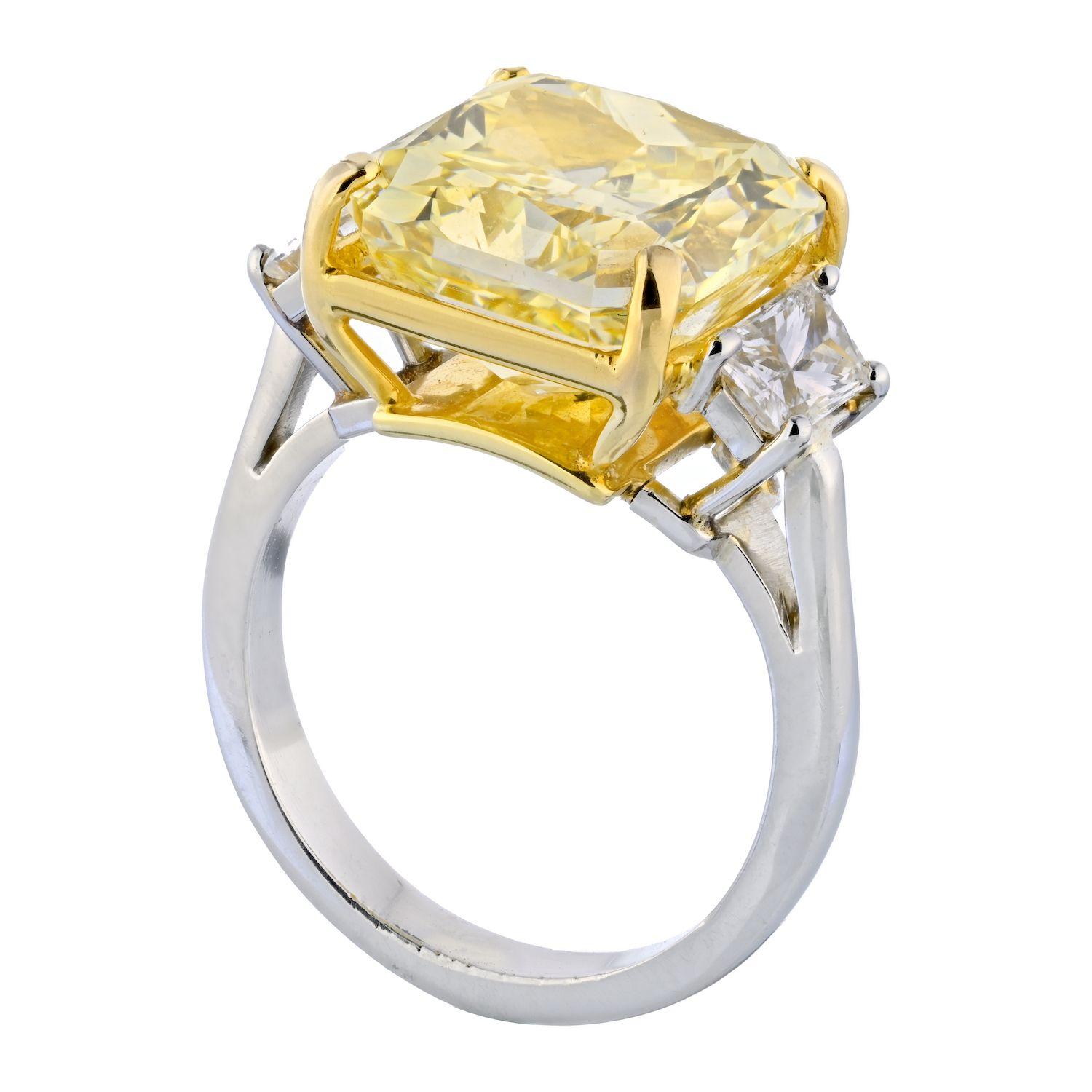 This is a stunning three stone diamond engagement ring crafted in Platinum and 18k yellow gold, mounted with a whopping 10.02 radiant cut diamond that is beyond spectacular. Rest assured everyone will notice you, your hand and your ring the moment