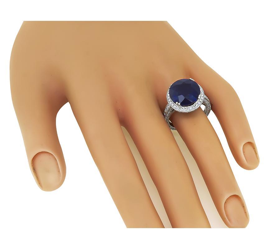 This is a gorgeous 18k white gold engagement ring. The ring is centered with a lovely round cut Ceylon sapphire that weighs approximately 10.02ct. The sapphire is accentuated by sparkling round cut diamonds that weigh approximately 2.50ct. The color