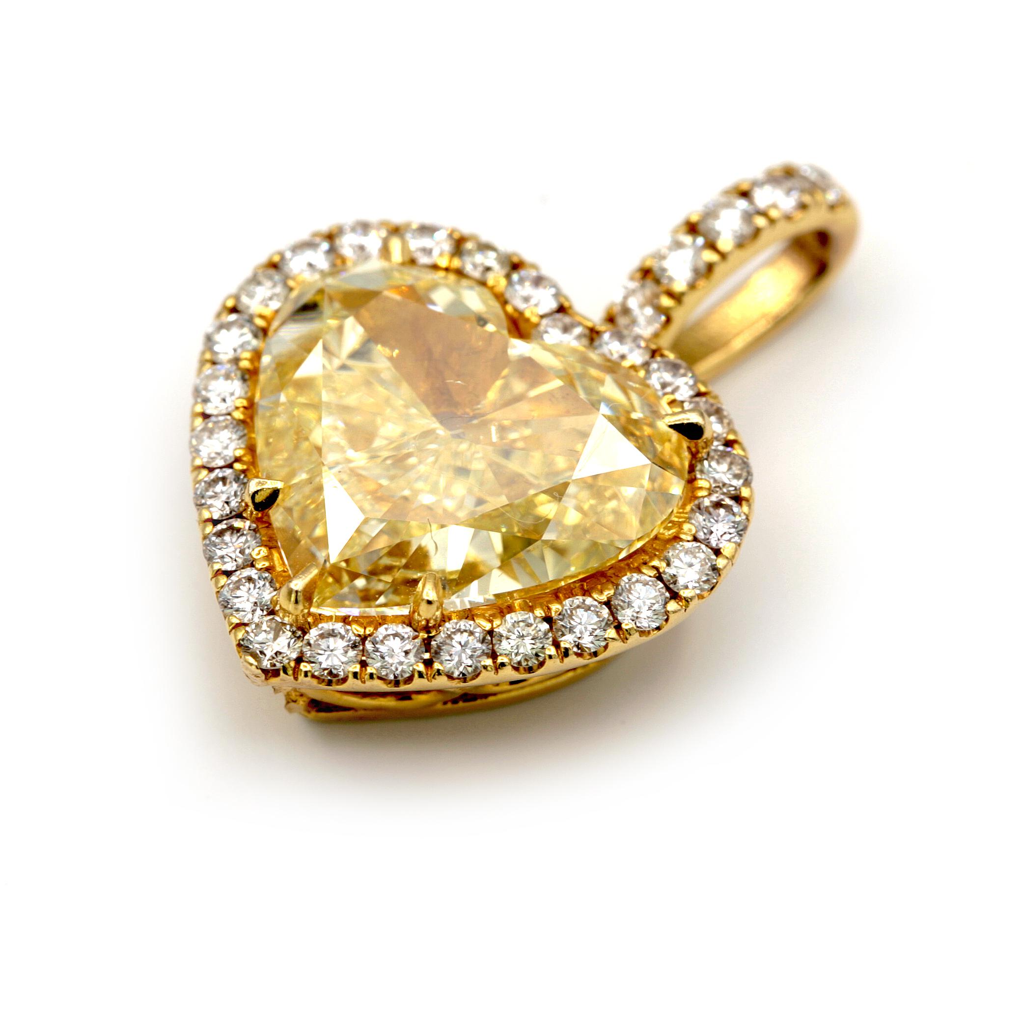 This 10.03 carat Yellow heart shape Diamond set in 18 karat yellow gold with 30 round white diamonds totaling approximately 1.50 carat. This spectacularly cut heart shape Yellow Diamond measures 20 x 19 millimeters.
